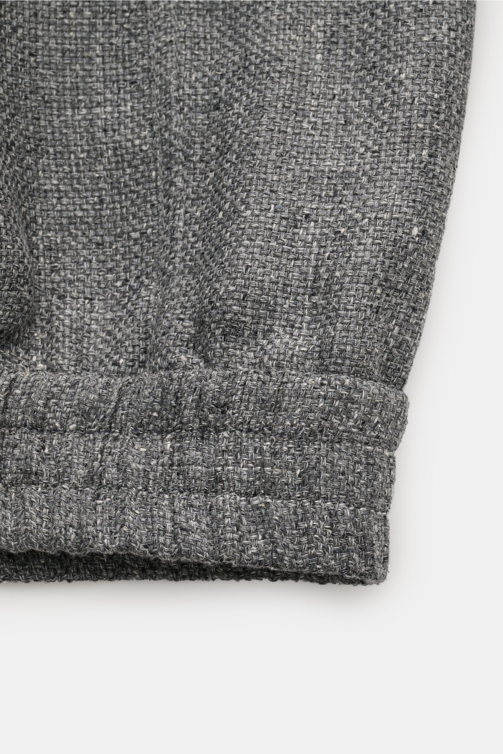 Close-up of the elastic hem and textured fabric detail of the Brunello Cucinelli Blouson sand meliert, photographed from the front. Luxus in jedem Detail: Von der Wahl des Mischgewebes aus Leinen und Wolle mit einem Anteil von Seide bis hin zur Denim-O
