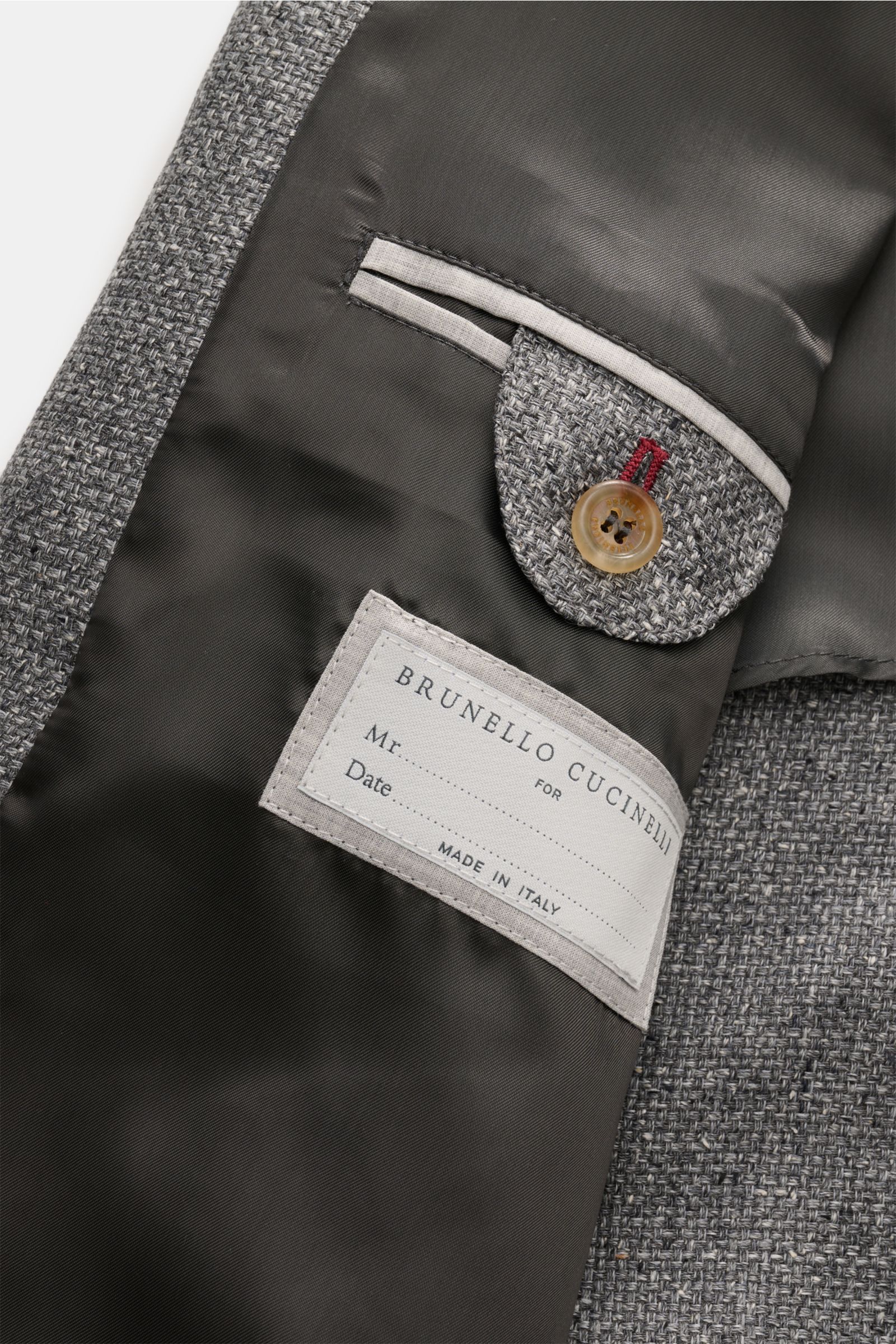 Close-up inside view of the Brunello Cucinelli Blouson sand meliert showing the woven fabric, buttoned inner pocket, and label with satin lining.

Luxus in jedem Detail: Von der Wahl des Mischgewebes aus Leinen und Wolle mit einem Anteil von Seide bis 