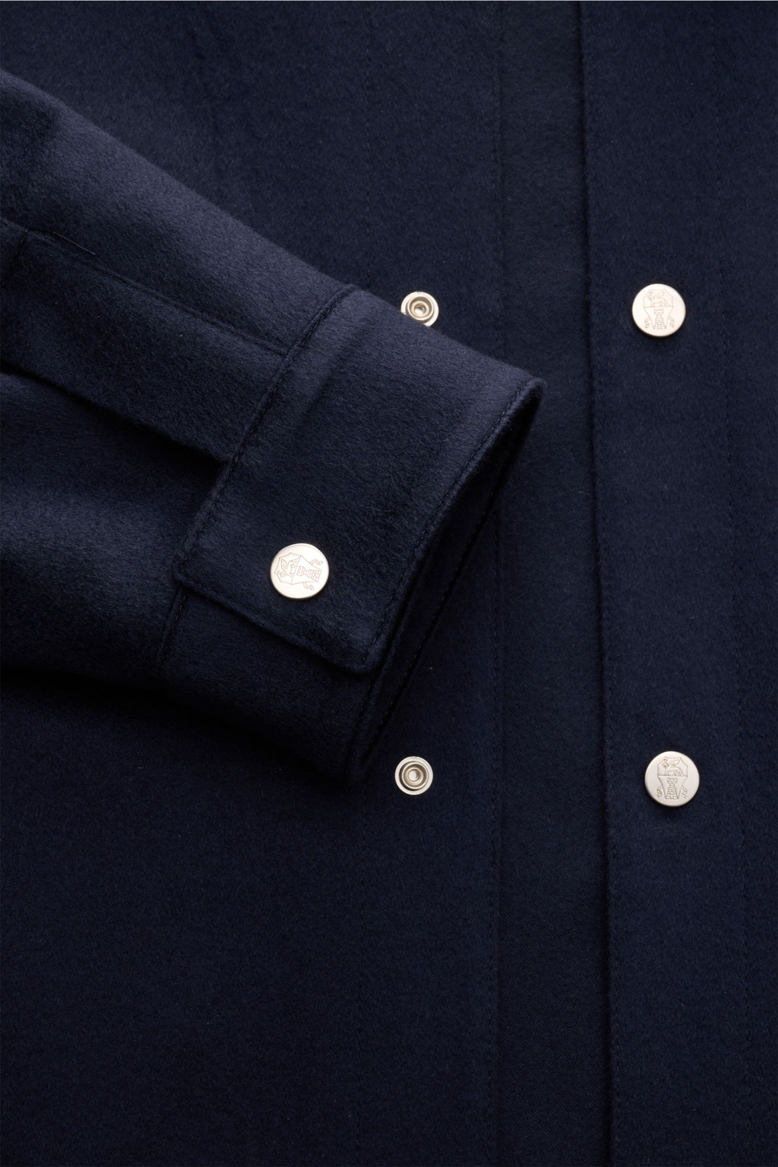 Brunello Cucinelli Cashmere Jacke navy detailed close-up of sleeve and snap button front, showcasing soft cashmere fabric texture from above.

