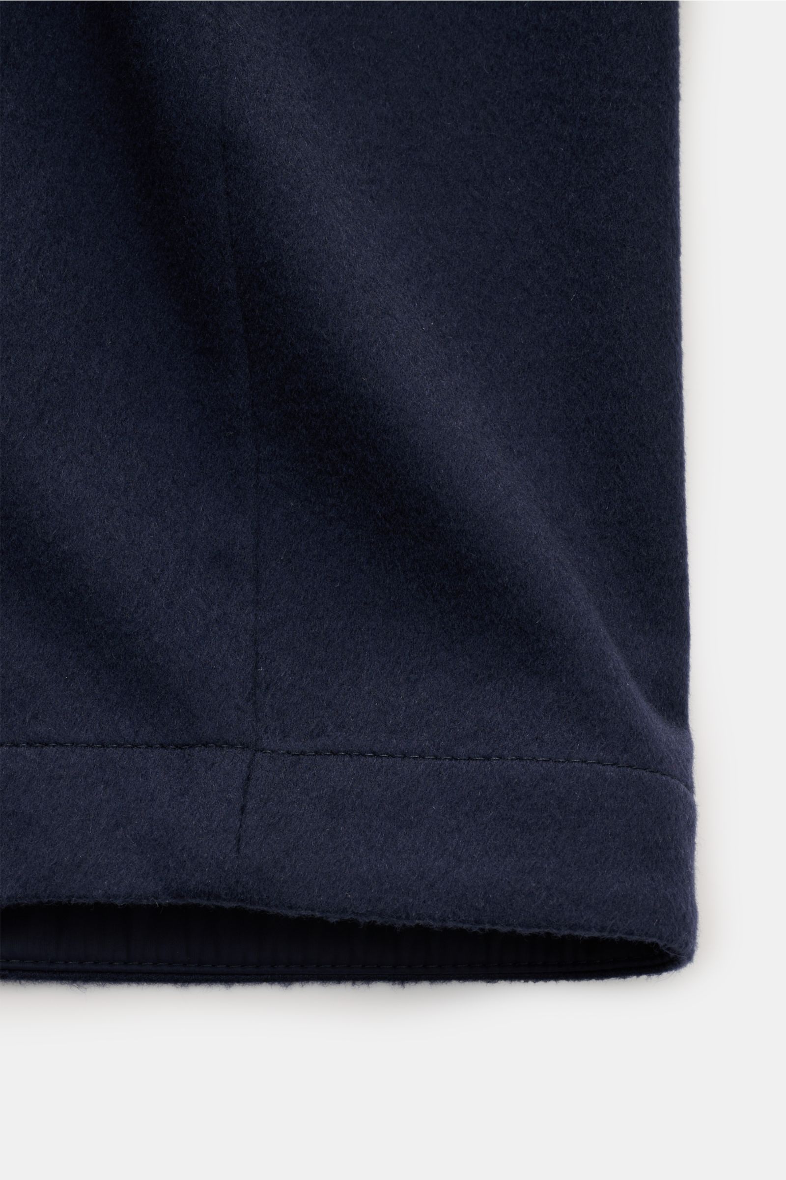 Close-up view of the lower hem of the Brunello Cucinelli Cashmere Jacke navy, showcasing its pure cashmere fabric and fine stitching.

