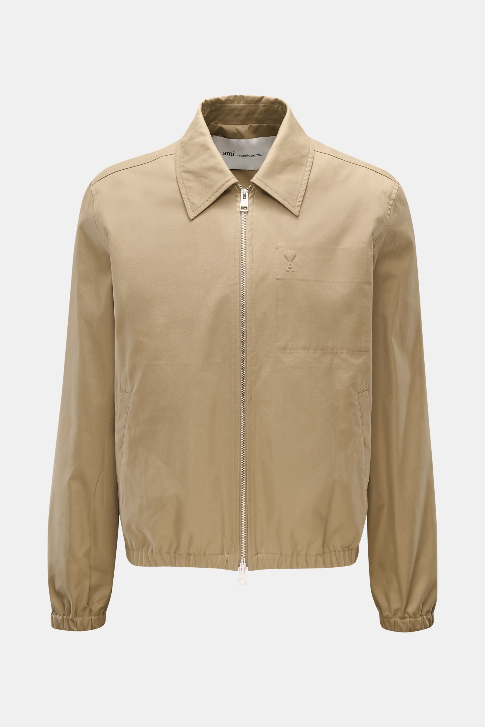 Front view of Ami Paris Blouson taupe, a slim fit jacket in pure cotton with soft touch, featuring a two-way zipper, turn-down collar, logo stitching on chest pocket, slanted welt pockets, elastic hem and cuffs, and an inner pocket. Stylish companion for 