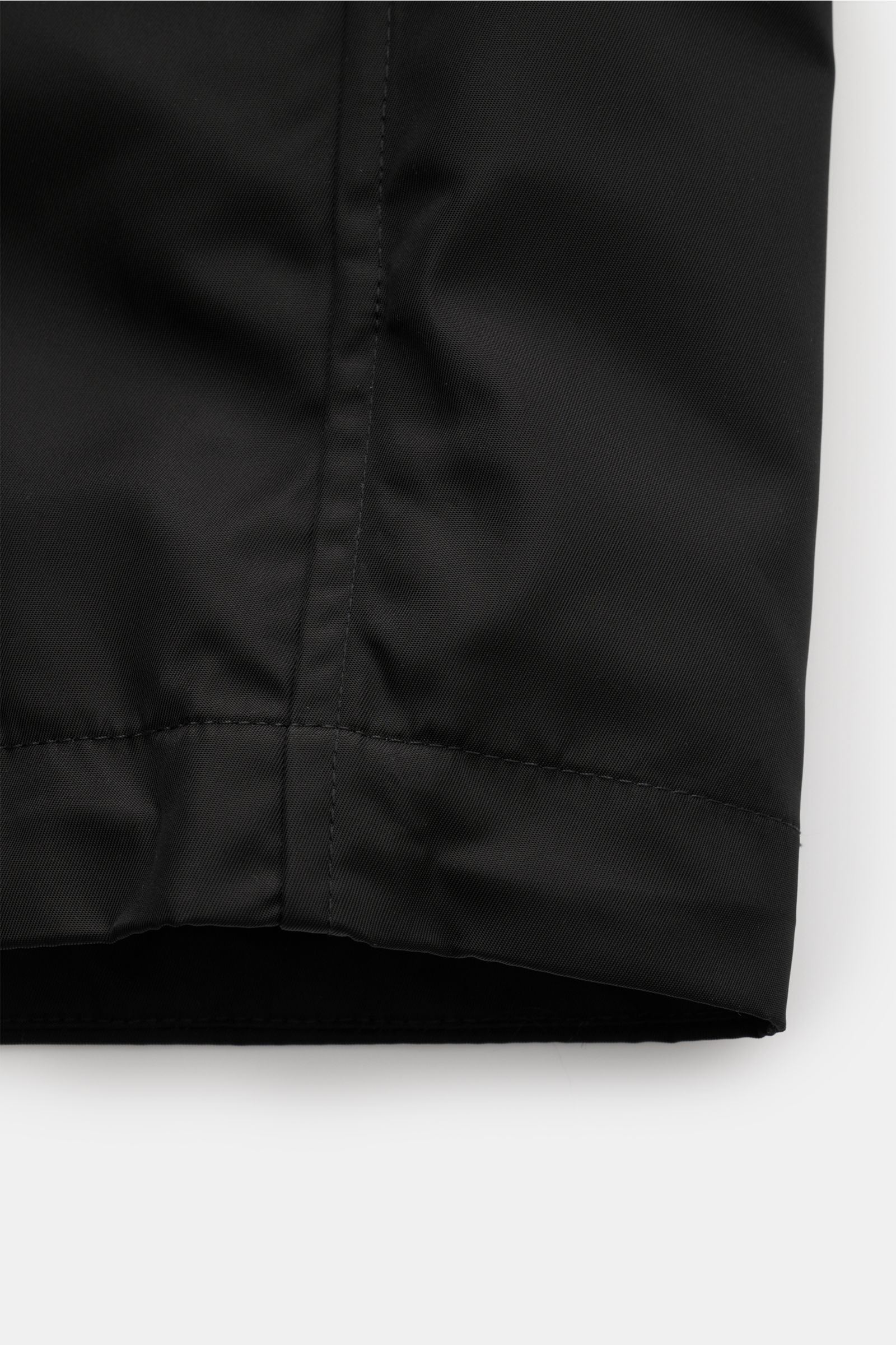 Close-up front view of the Ami Paris Jacke schwarz hem, made of smooth high-quality microfiber with a regular fit and unconstructed design. Stilvoll durch die Übergangszeit: Die AMI PARIS Jacke besticht mit legerem Schnitt und vielseitigen Kombinationsmög