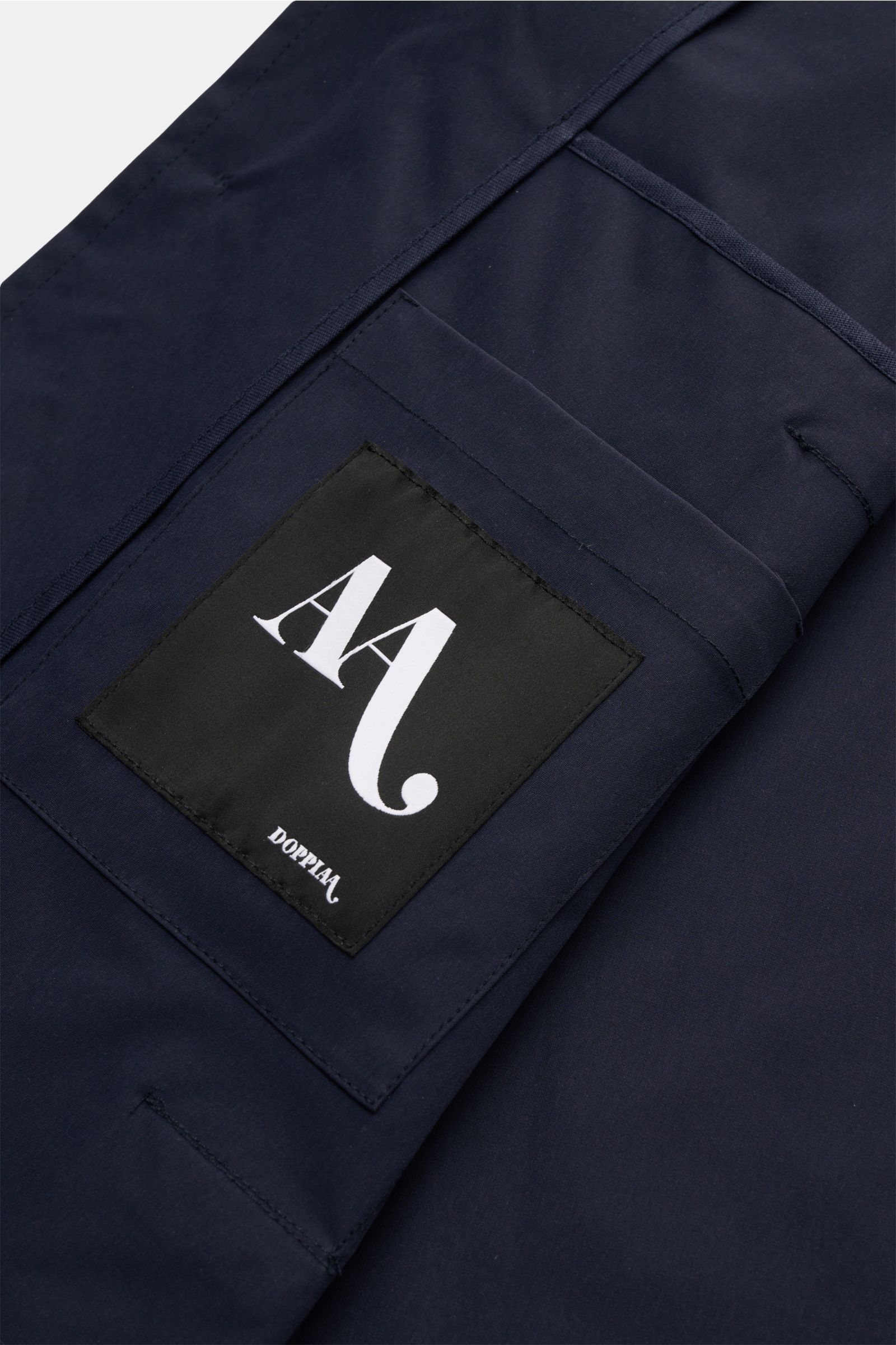 Close-up, top-down view of the Doppiaa Jacket 'Aarneis' navy showing the black patch with white 'AA' logo on high-quality microfibre fabric. Timeless elegance for the transitional season: The jacket 'Aarneis' by DOPPIAA combines a clean design with a vers