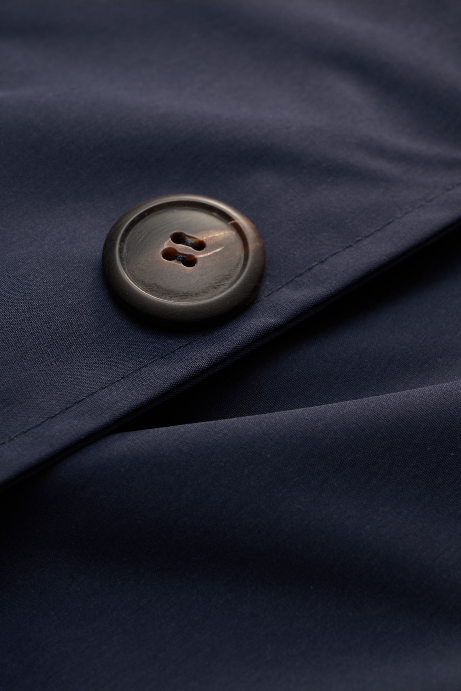Close-up front view of the Doppiaa Jacket 'Aarneis' navy showing a large dark button on smooth, high-quality microfiber fabric with a slim fit, four-button placket, turn-down collar, jetted front pockets, button cuffs, unconstructed design, and two inside