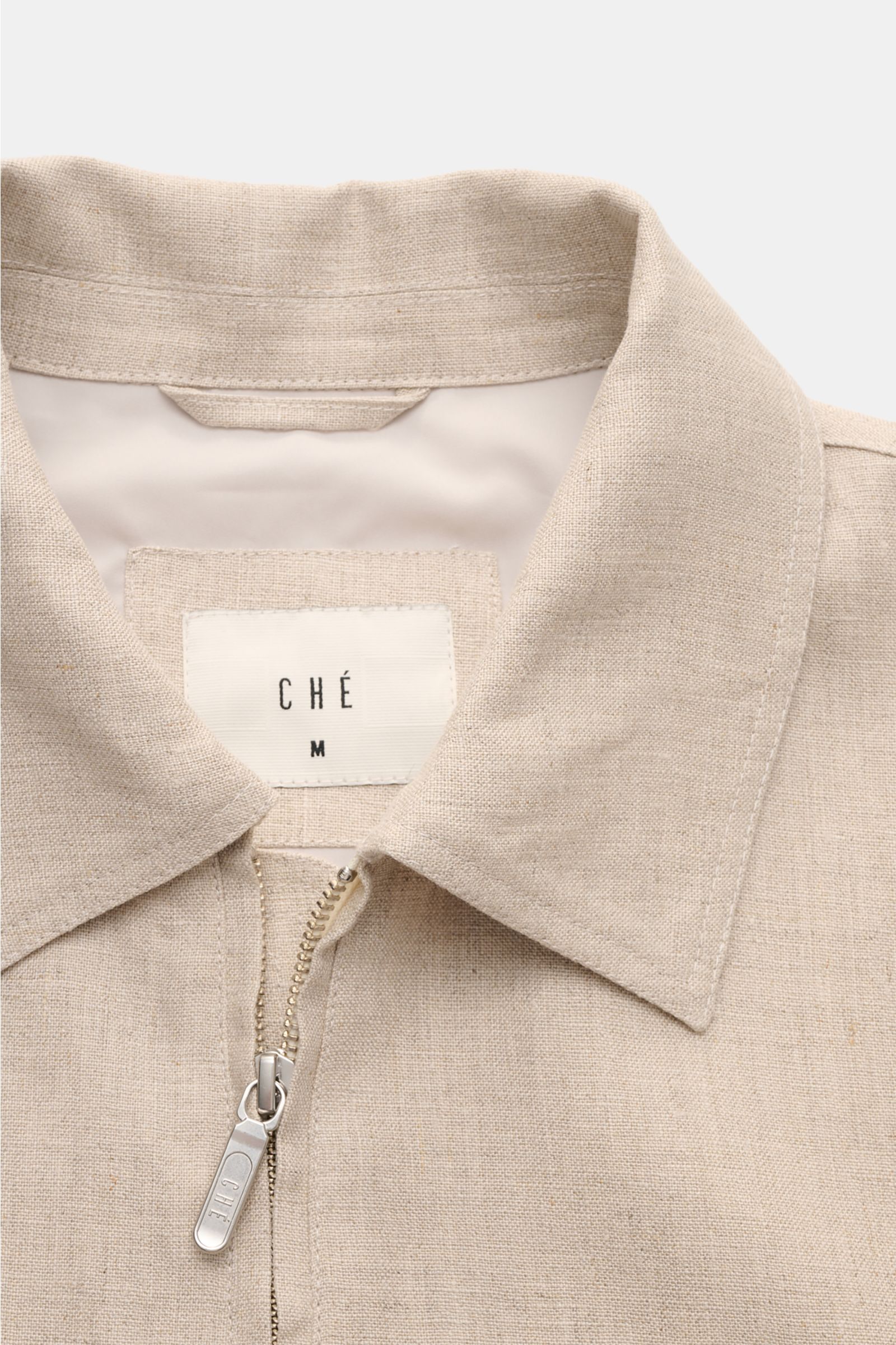 Nahaufnahme des Kragens und robusten Reißverschlusses des Ché Blouson 'Benito' beige meliert aus leicht griffigem, reinem Leinen mit Umlegekragen.