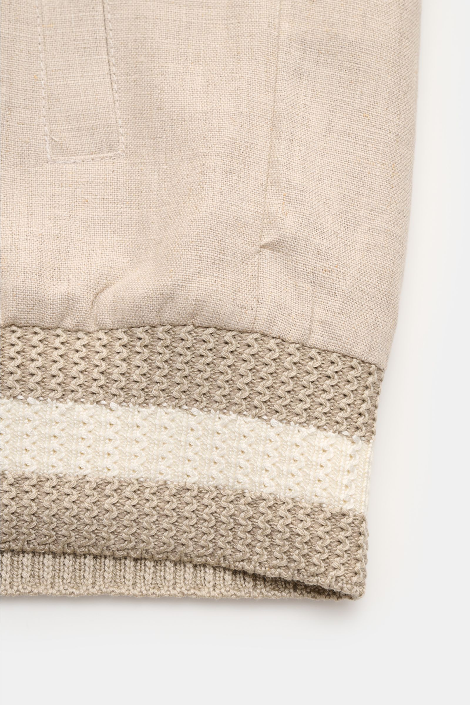 Nahaufnahme des elastischen Saum- und Ärmelbündchens des Ché Blouson 'Benito' beige meliert aus leicht griffigem, reinem Leinen.