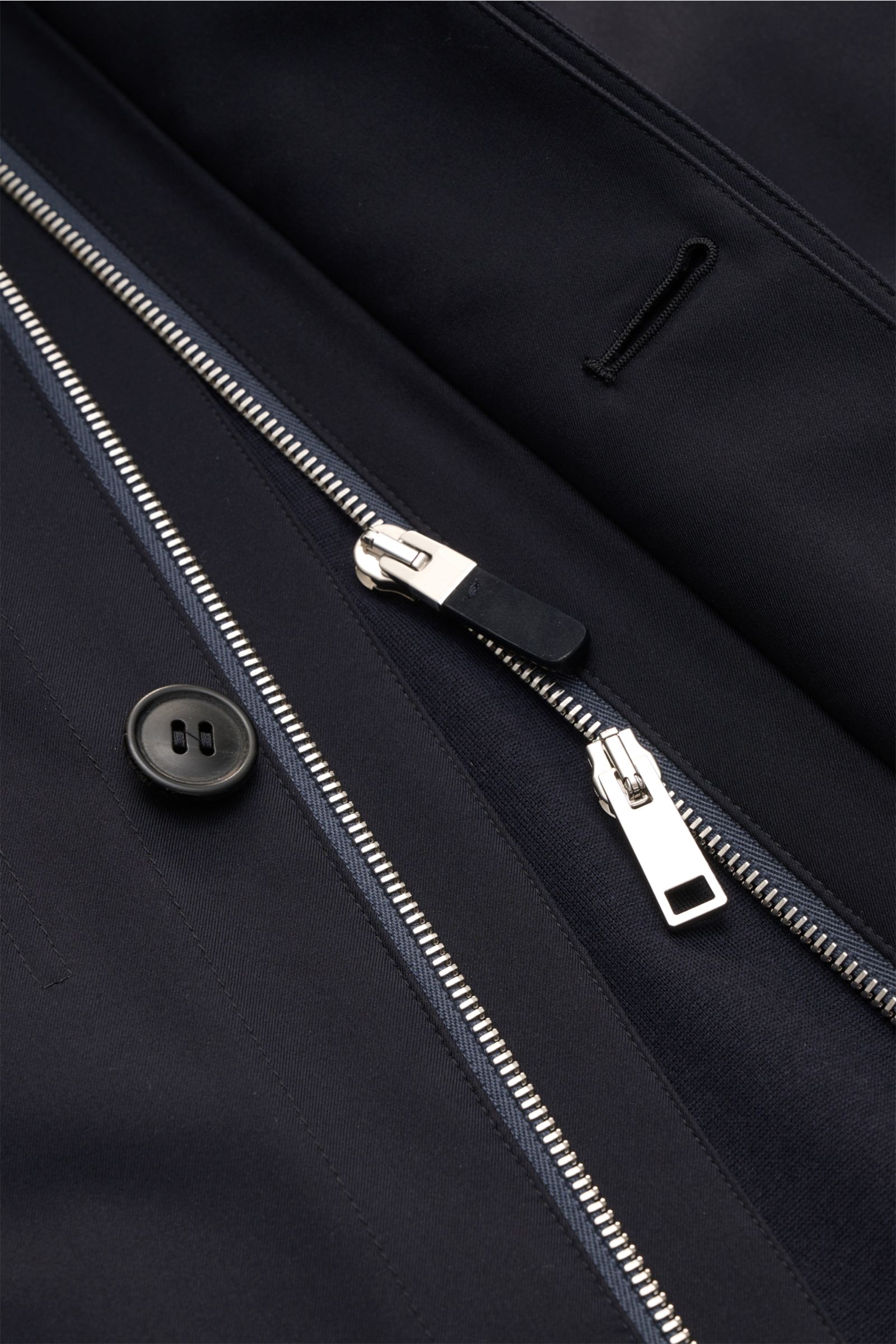 Zegna Jacket 'Motorin' navy close-up from above showing black button, metal two-way zipper, and finely stitched buttonhole on smooth microfibre fabric. 