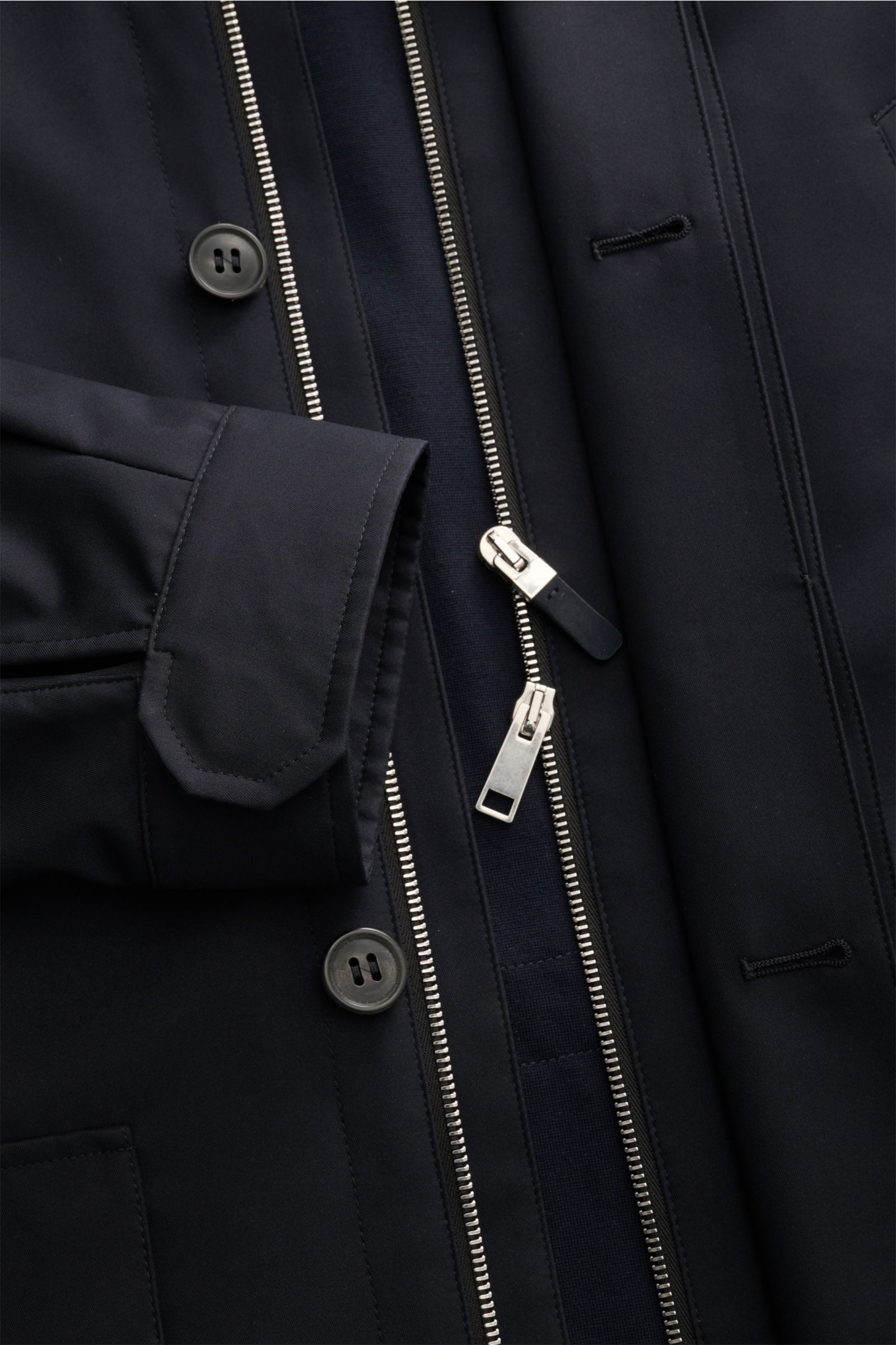 Nahaufnahme der Zegna Jacke 'Motorino' navy von vorne schräg oben, zeigt wind- und wasserabweisende Microfaser mit Reißverschluss, Knöpfen, Manschette und Brusttasche.