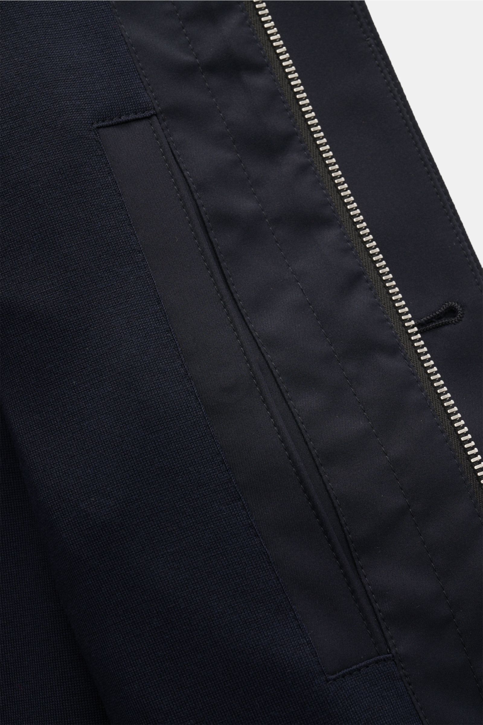Nahaufnahme der Reißverschluss- und Taschenpartie der Zegna Jacke 'Motorino' navy aus hochwertiger Microfaser mit tonalem Wolljersey-Futter.