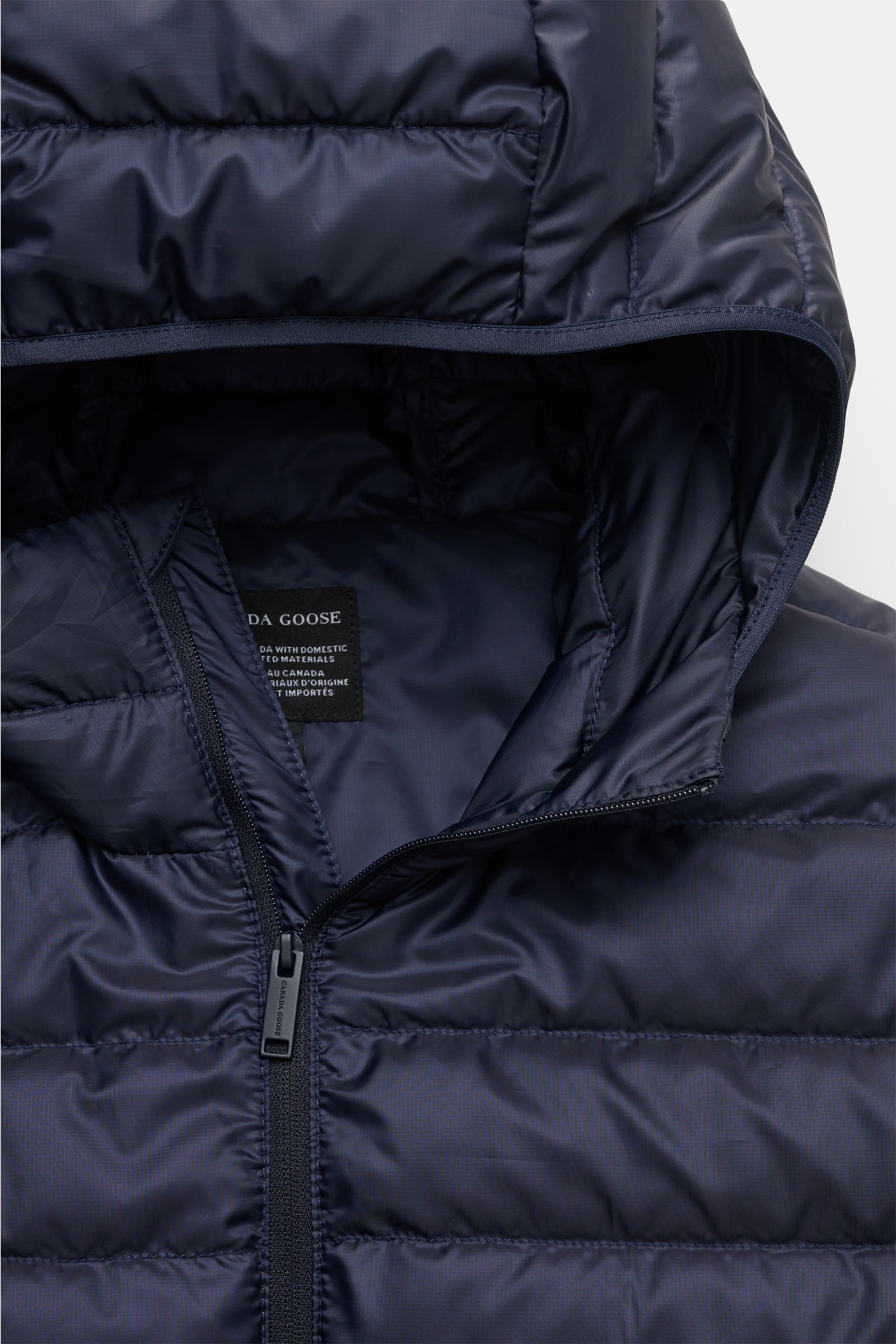 Close-up front view of Canada Goose Down jacket 'Stratus Hoody' navy showing zip and padded hood with ripstop fabric and smooth finish.
