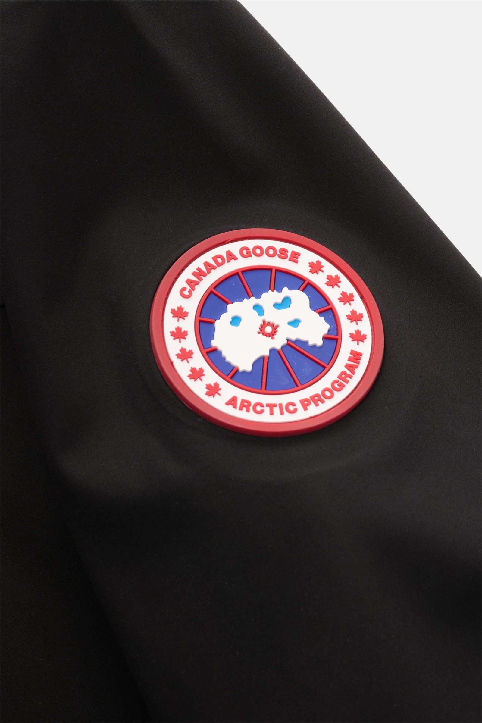 Nahaufnahme der Canada Goose Jacke 'Rupert' schwarz mit Logo-Patch aus glatter, wasserdichter Microfaser, funktional für Übergangszeit.