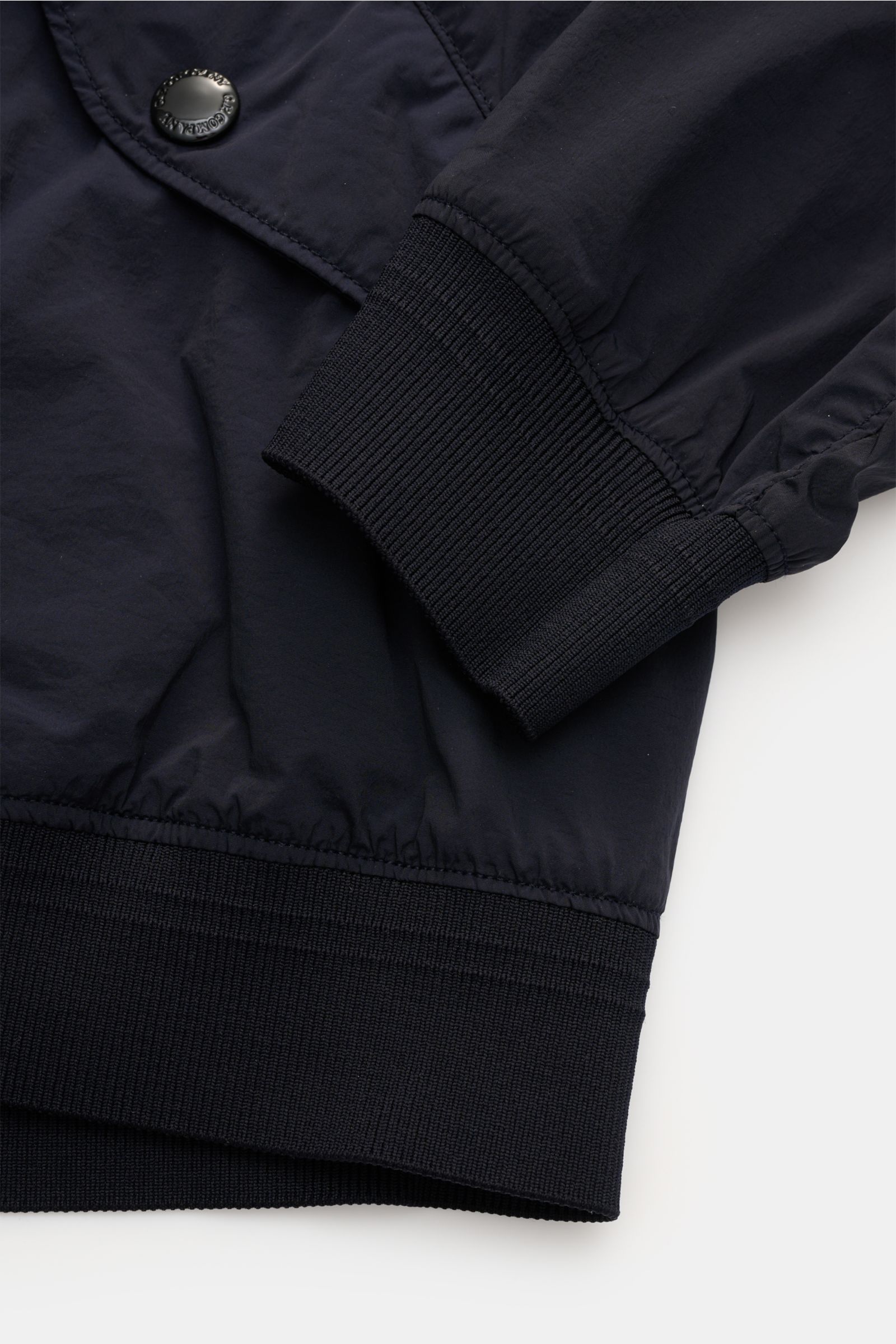 Nahaufnahme des C.P. Company Blouson 'Nycra R' dark navy, zeigt elastische, gerippte Bündchen und glatte, recycelte Microfaser.