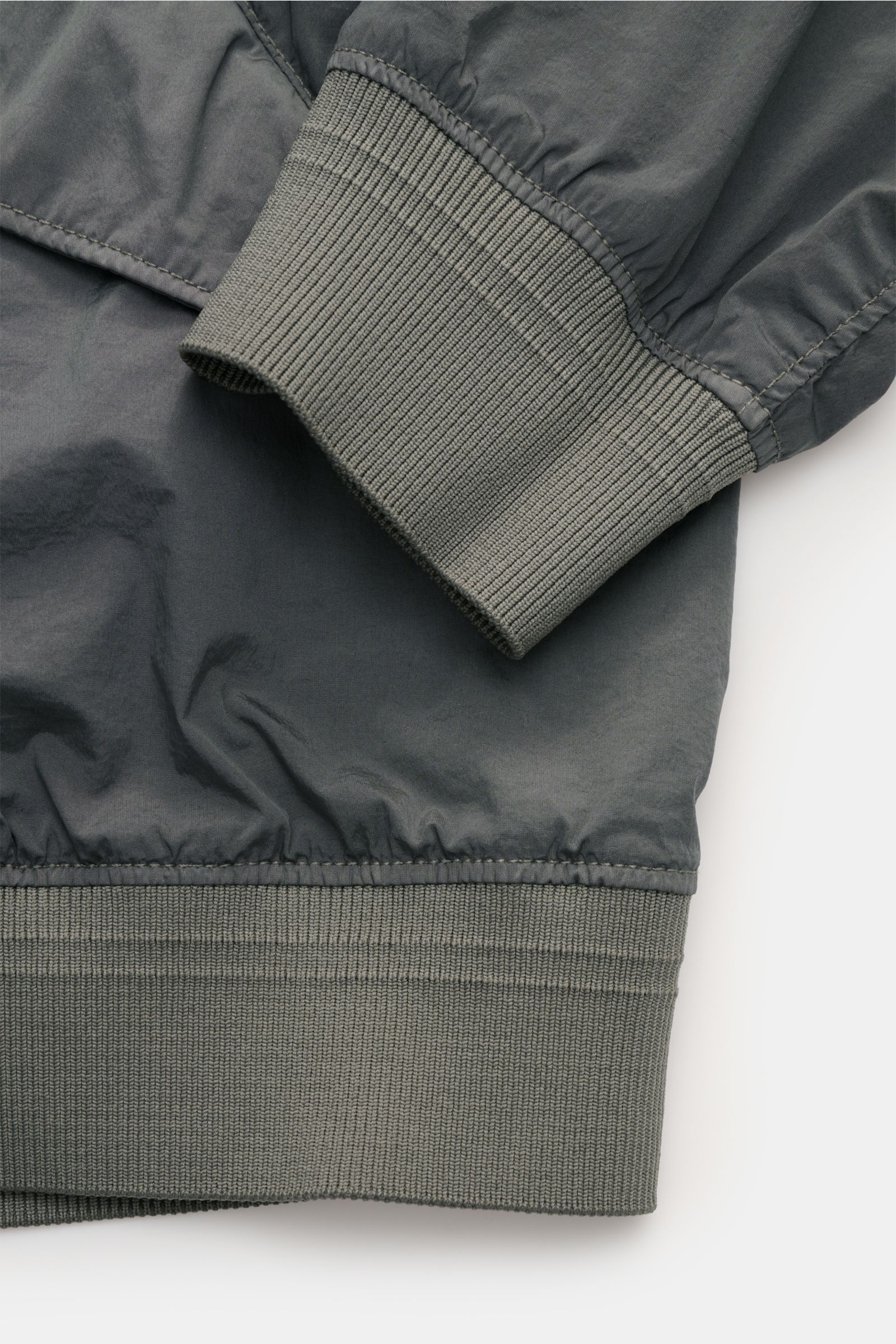 C.P. Company Blouson 'Nycra R' grau im Detail, Nahaufnahme von Ärmel- und Saum-Rippbündchen, recycelte Microfaser, leicht, wind- und wasserabweisend, Slim Fit.