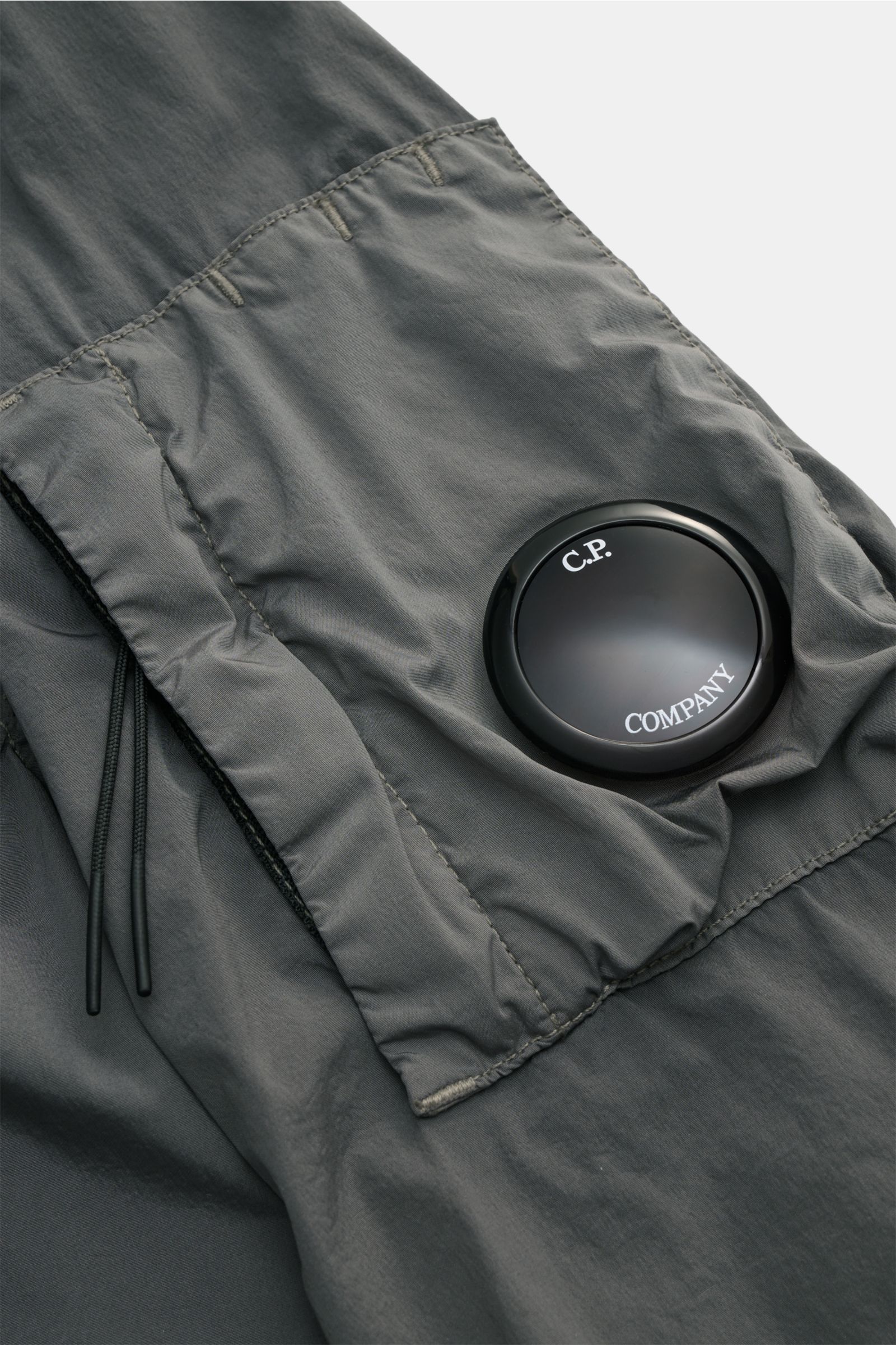 Nahaufnahme des Ärmels mit Ärmeltasche und Linsen-Detail des C.P. Company Blouson 'Nycra R' grau aus recycelter Microfaser.