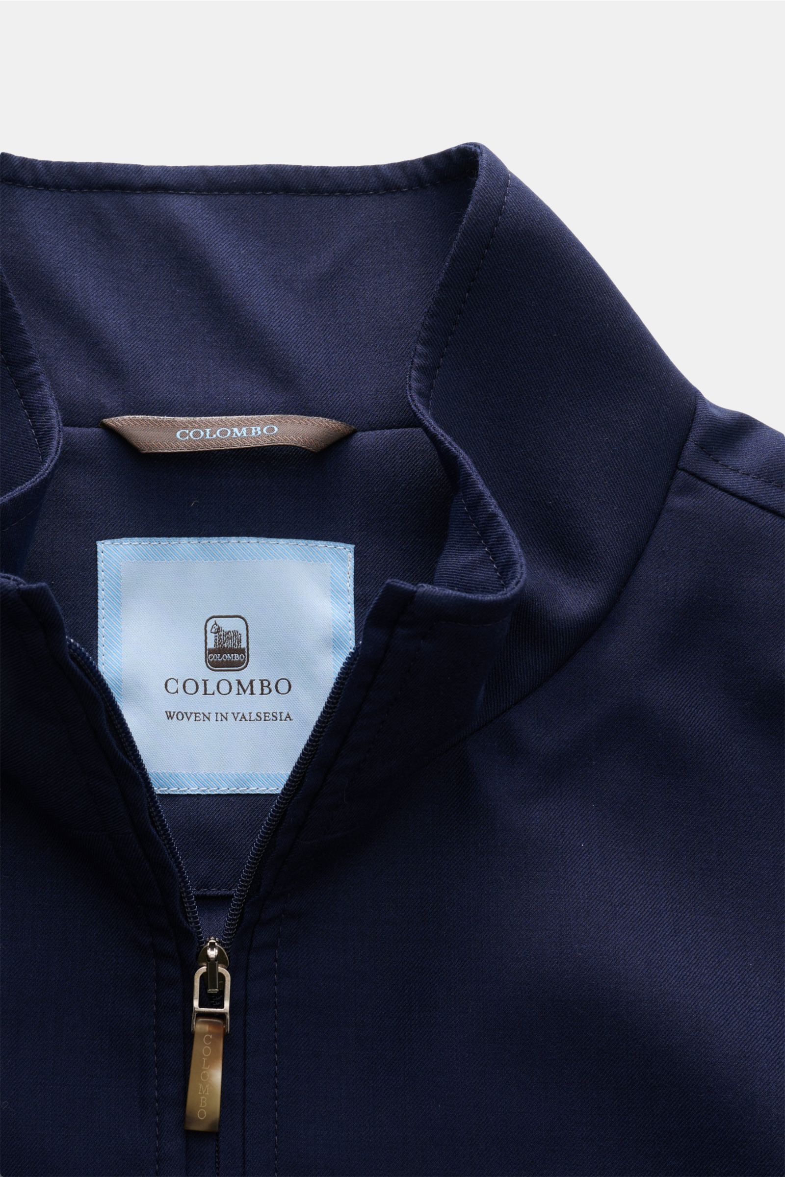 Colombo Cashmere jacket navy shown from a close-up front perspective, highlighting the standing collar and two-way zip, with label inside. An expression of the finest craftsmanship: This cashmere jacket by COLOMBO combines exquisite fabric with a flawless