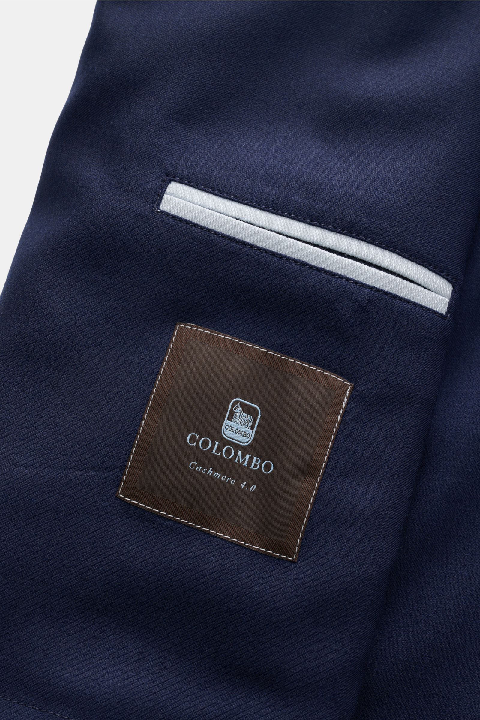 Close-up view of the Colombo Cashmere jacket navy fabric and inner jetted pocket with COLOMBO label, showcasing finest craftsmanship. An expression of the finest craftsmanship: This cashmere jacket by COLOMBO combines exquisite fabric with a flawless f