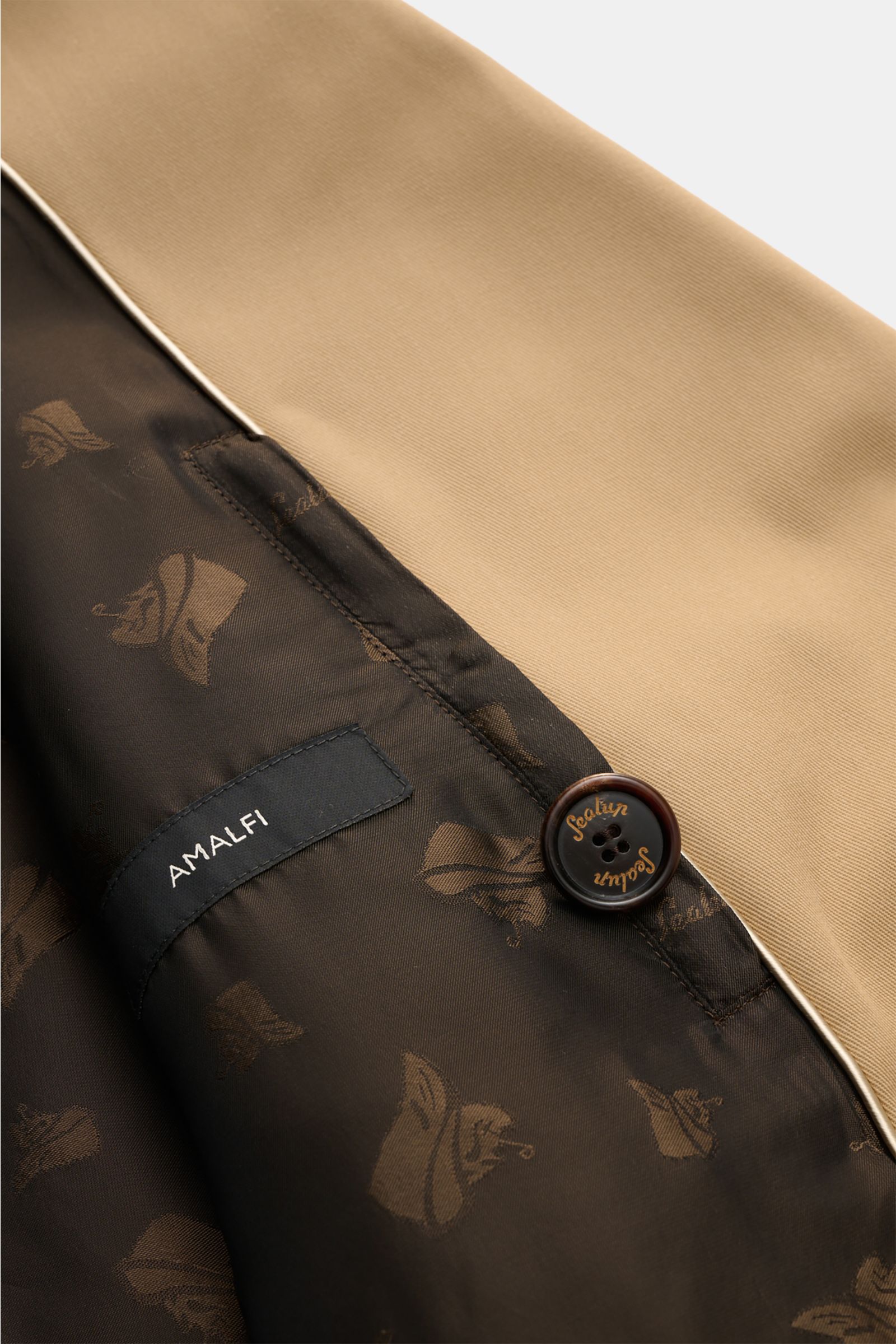Close-up inside view of Sealup Pea coat 'Amalfi' beige showing smooth black lining with logo, Amalfi label, and branded button. Get the look of a Hanseatic merchant with the elegant pea coat 'Amalfi' by traditional label SEALUP: made of lightweight twill 