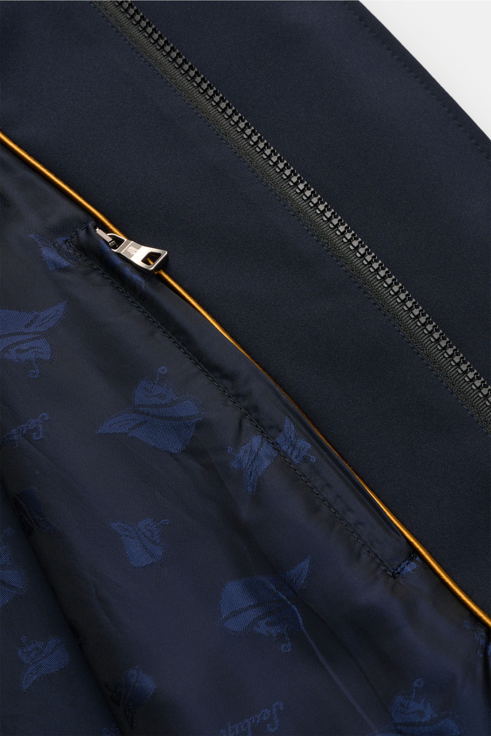 Nahaufnahme des innenliegenden Reißverschlusses und des gemusterten Innenfutters des Sealup Parka 'Hurricane' navy aus glatter Microfaser.