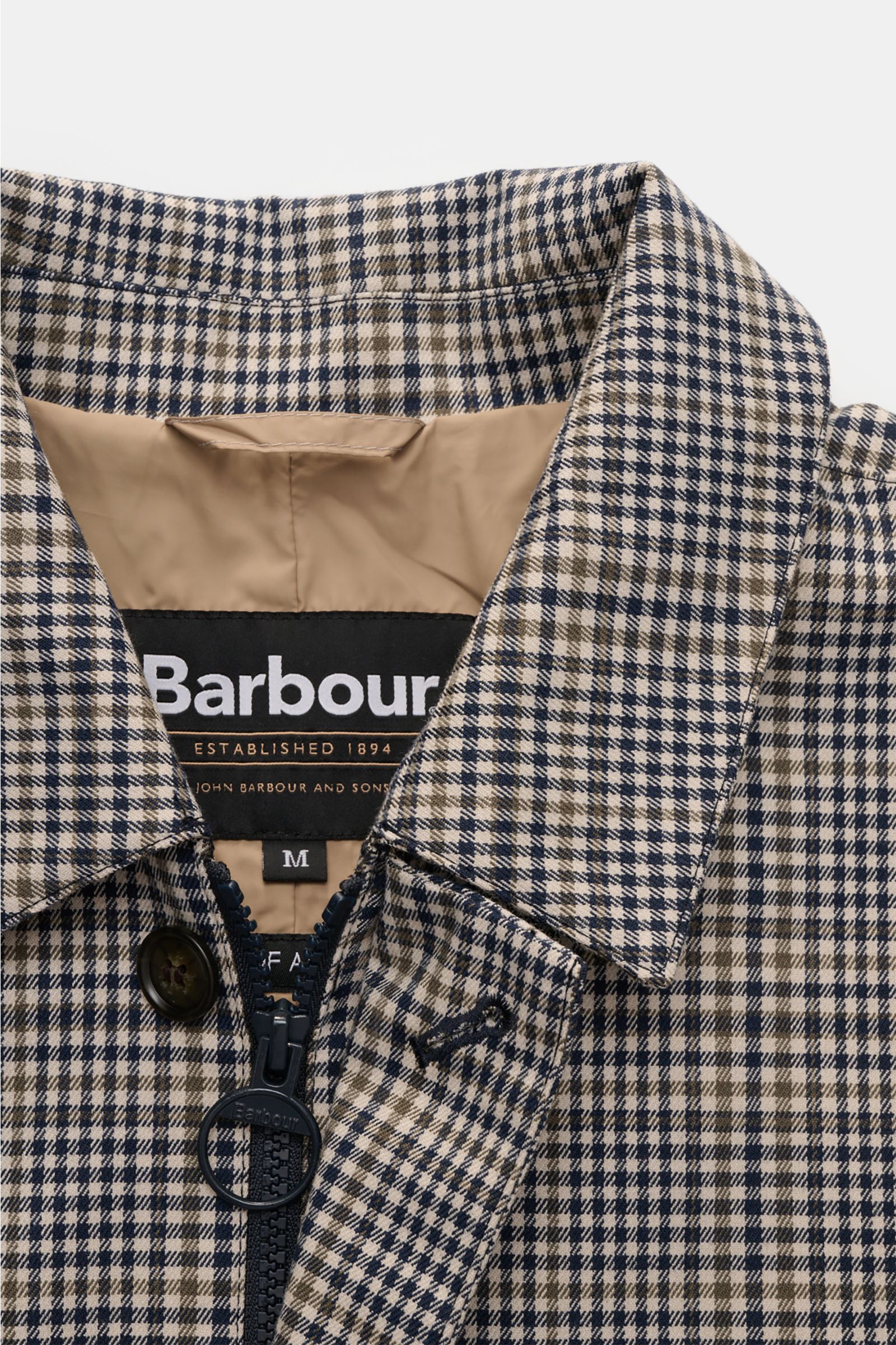 Close-up front view of Barbour Rain coat 'Check Rokig' navy/olive checked collar, zipper, and label showing slim fit, waterproof design.