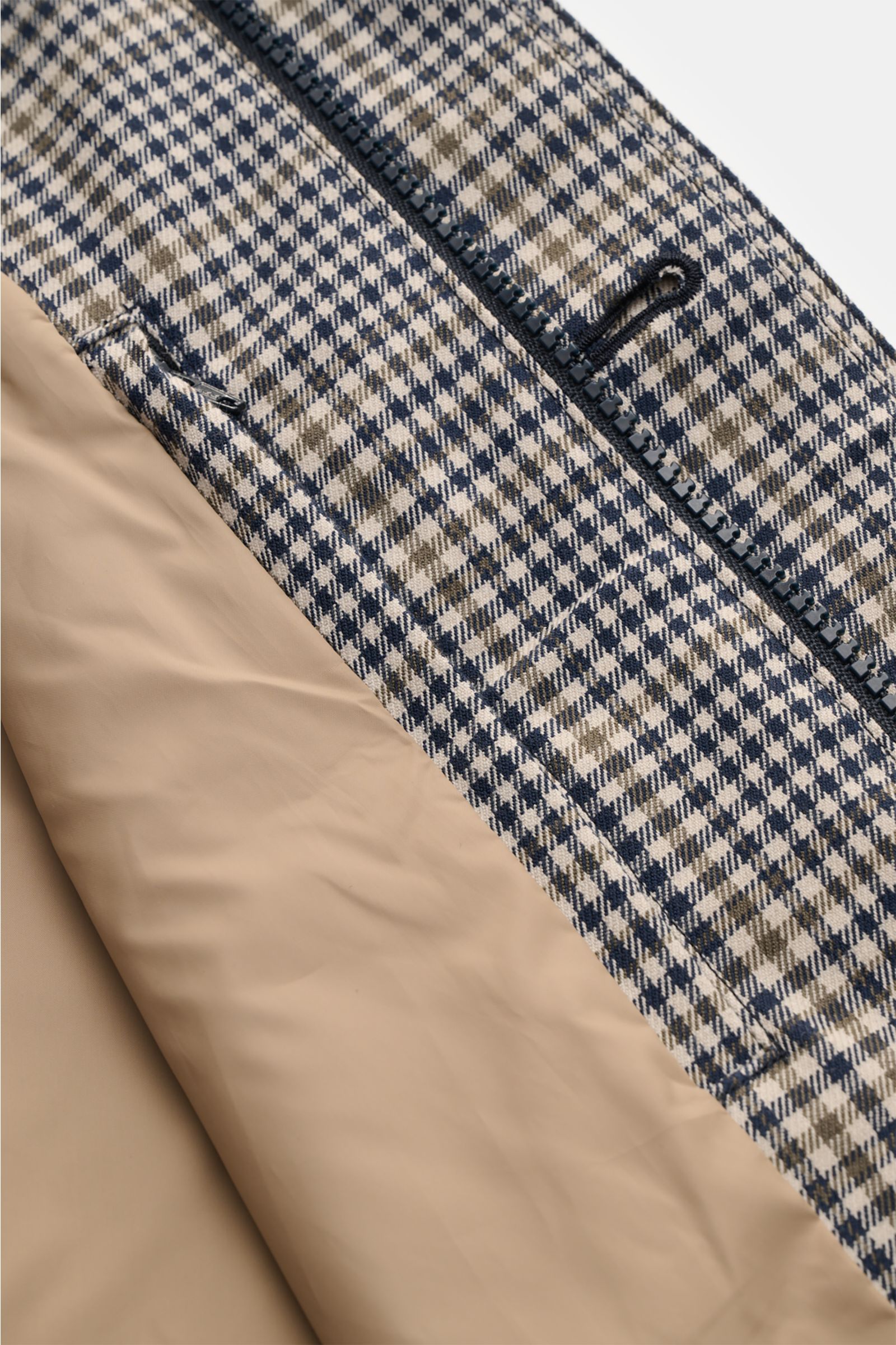 Close-up view of the Barbour Rain coat 'Check Rokig' navy/olive checked showing the waterproof checked outer fabric with a two-way zip and beige smooth lining inside. 

Be ready for changeable weather with the lightweight rain coat 'Check Rokig' by BAR