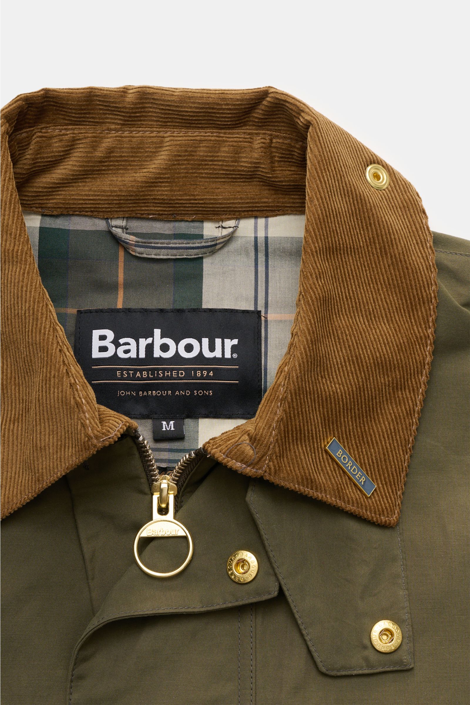 Close-up front view of Barbour Waxed jacket 'Icons Border Casual' olive showing brown corduroy collar, gold zipper and snap buttons.

Description: Perfectly equipped for the transitional season: The waxed jacket 'Border' combines dependable weather pro