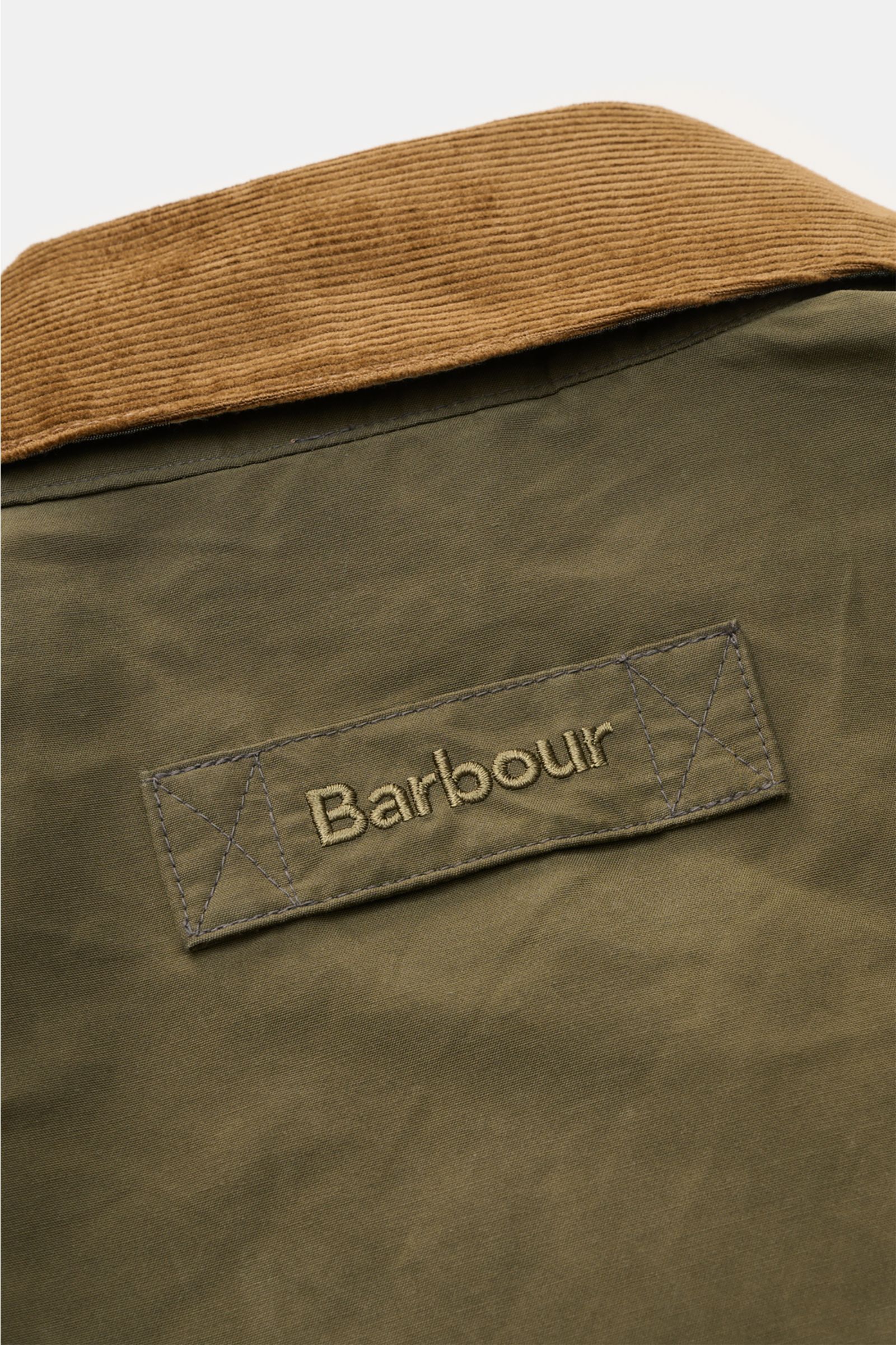 Close-up rear view of the Barbour Waxed jacket 'Icons Border Casual' olive showing the corduroy collar and embroidered logo patch.

Perfectly equipped for the transitional season: The waxed jacket 'Border' combines dependable weather protection with ma