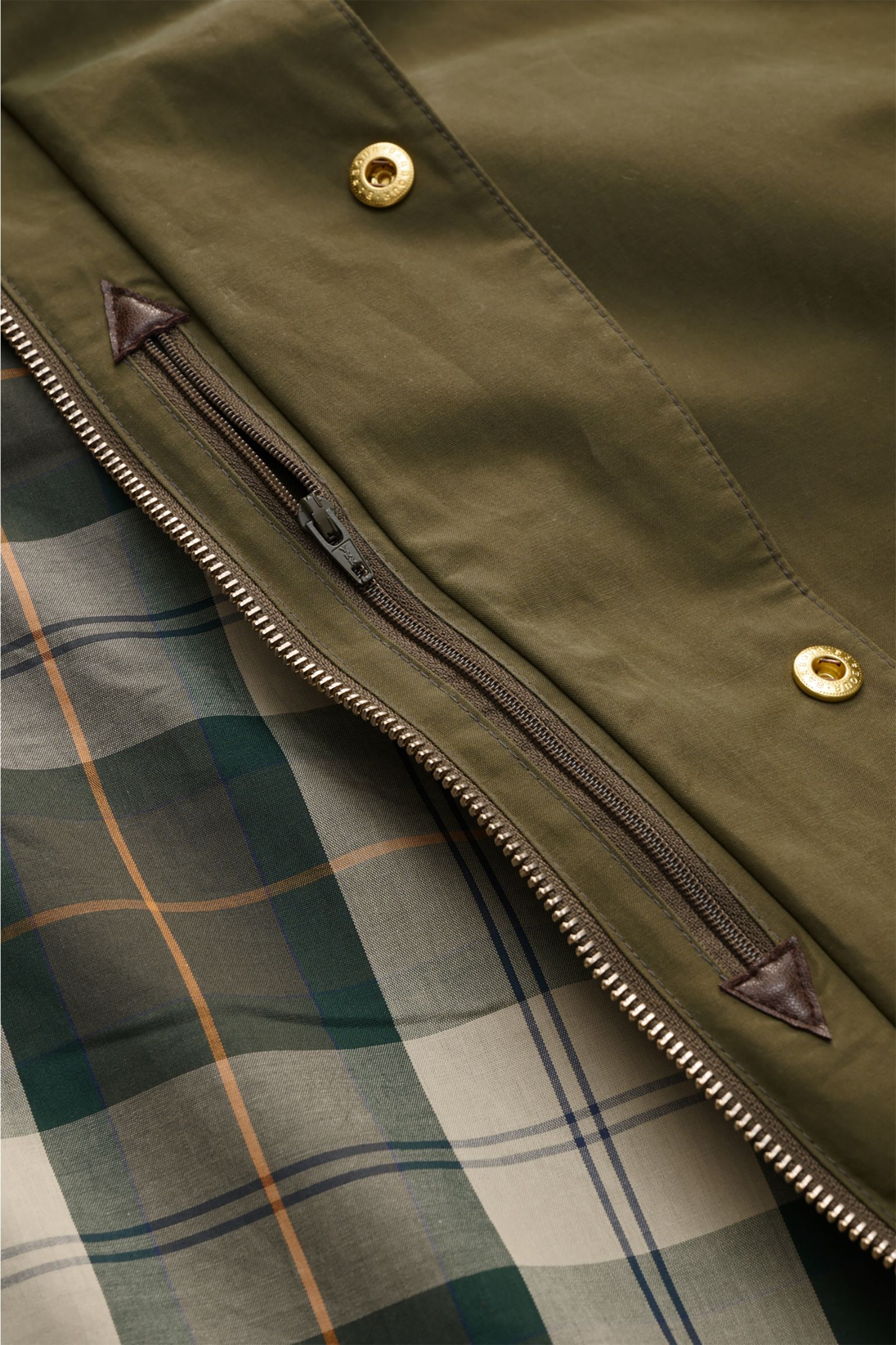 Close-up front view of Barbour Waxed jacket 'Icons Border Casual' olive showing waxed cotton fabric, robust two-way zip, snap buttons, and signature tartan lining.

Description: Perfectly equipped for the transitional season: The waxed jacket 'Border' 