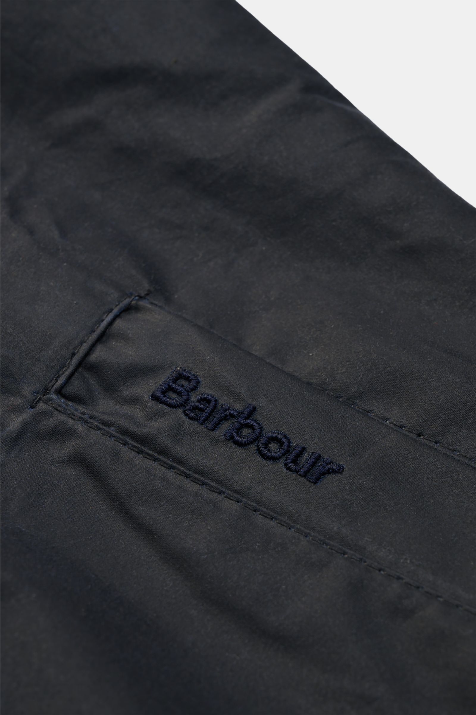 Close-up front pocket view of Barbour Waxed blouson 'Royston' dark navy in waxed cotton with embroidered logo, slim fit, corduroy collar.

Classic blouson by traditional label BARBOUR: With its short cut and signature corduroy trim on the collar, the m