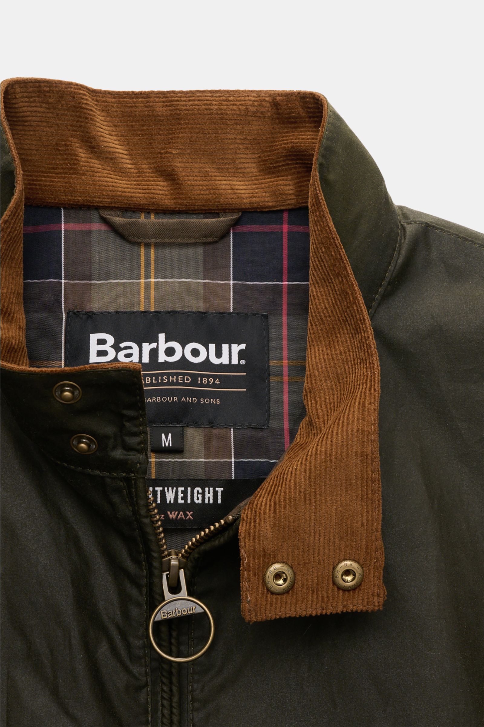 Close-up front view of Barbour Waxed blouson 'Royston' dark olive jacket, showing brown corduroy collar, two snap buttons, ring zipper, and tartan lining. Classic blouson by traditional label BARBOUR: With its short cut and signature corduroy trim on the 