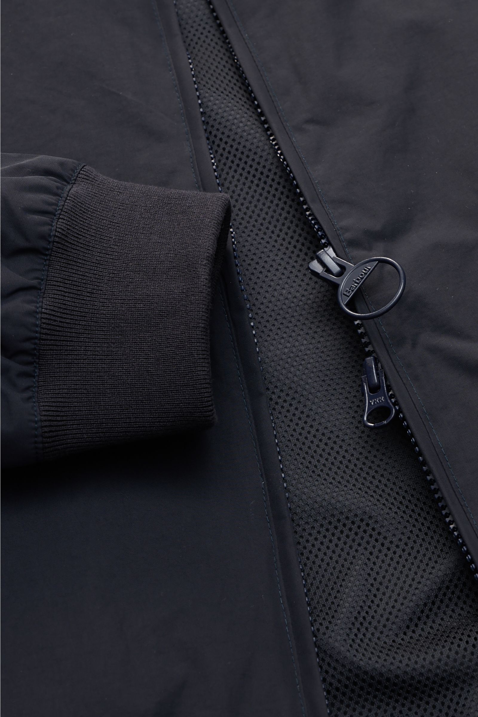 Close-up front view of Barbour Blouson 'Royston' navy showing ribbed cuff, two-way zip with branded pull, and mesh lining.

Modern blouson by traditional label BARBOUR: With its short cut and signature corduroy trim on the collar, the model 'Royston' i