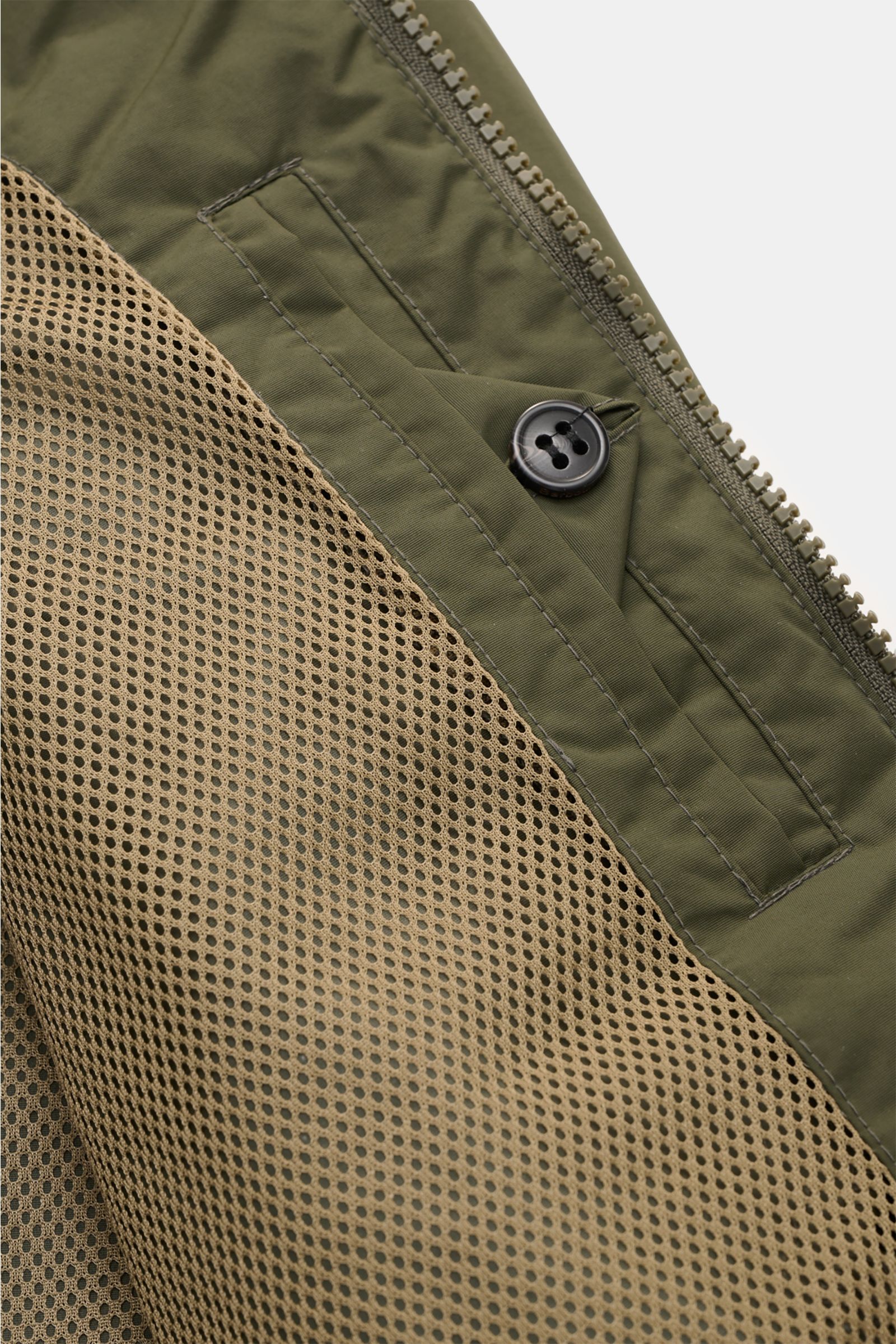 Close-up top-down view of the inside pocket and mesh lining of the Barbour Blouson 'Royston' olive jacket, showing button and zipper details.

Modern blouson by traditional label BARBOUR: With its short cut and signature corduroy trim on the collar, th