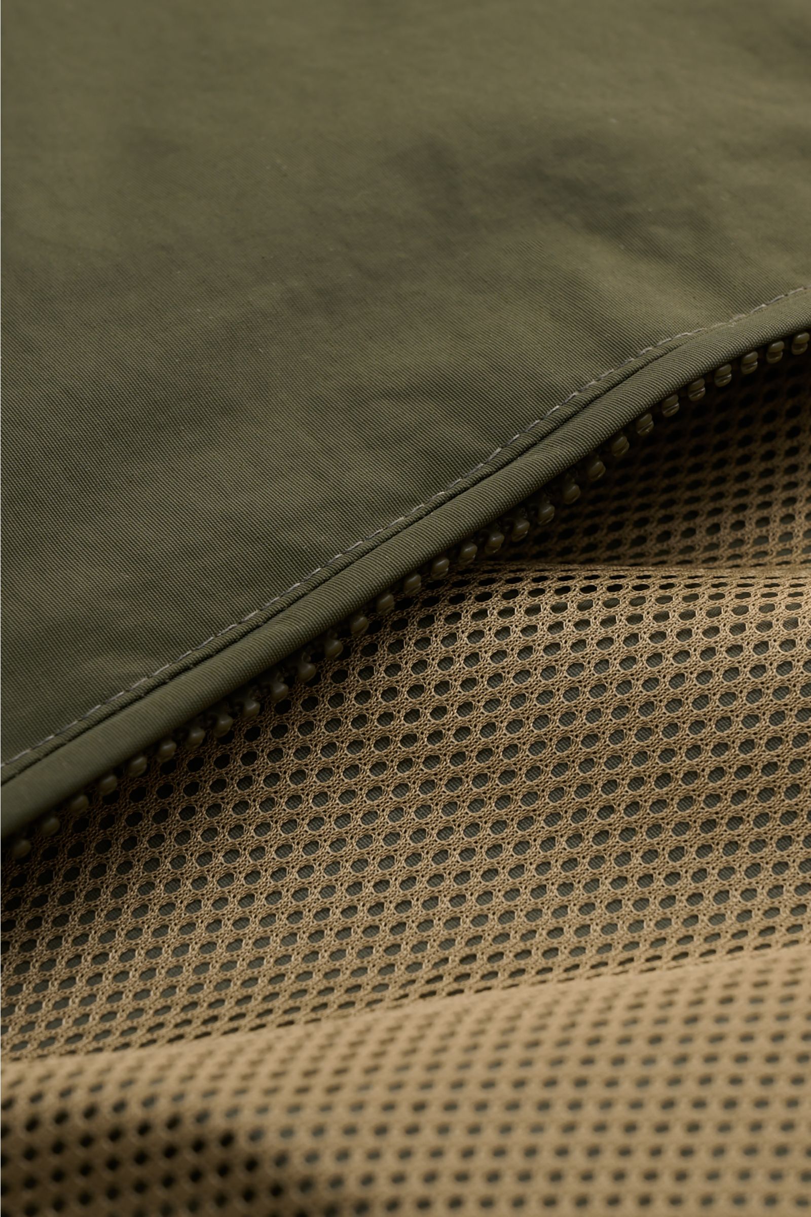 Close-up view of the Barbour Blouson 'Royston' olive showing the high-quality microfibre outer fabric and beige mesh lining with detailed stitching.  
Modern blouson by traditional label BARBOUR: With its short cut and signature corduroy trim on the co