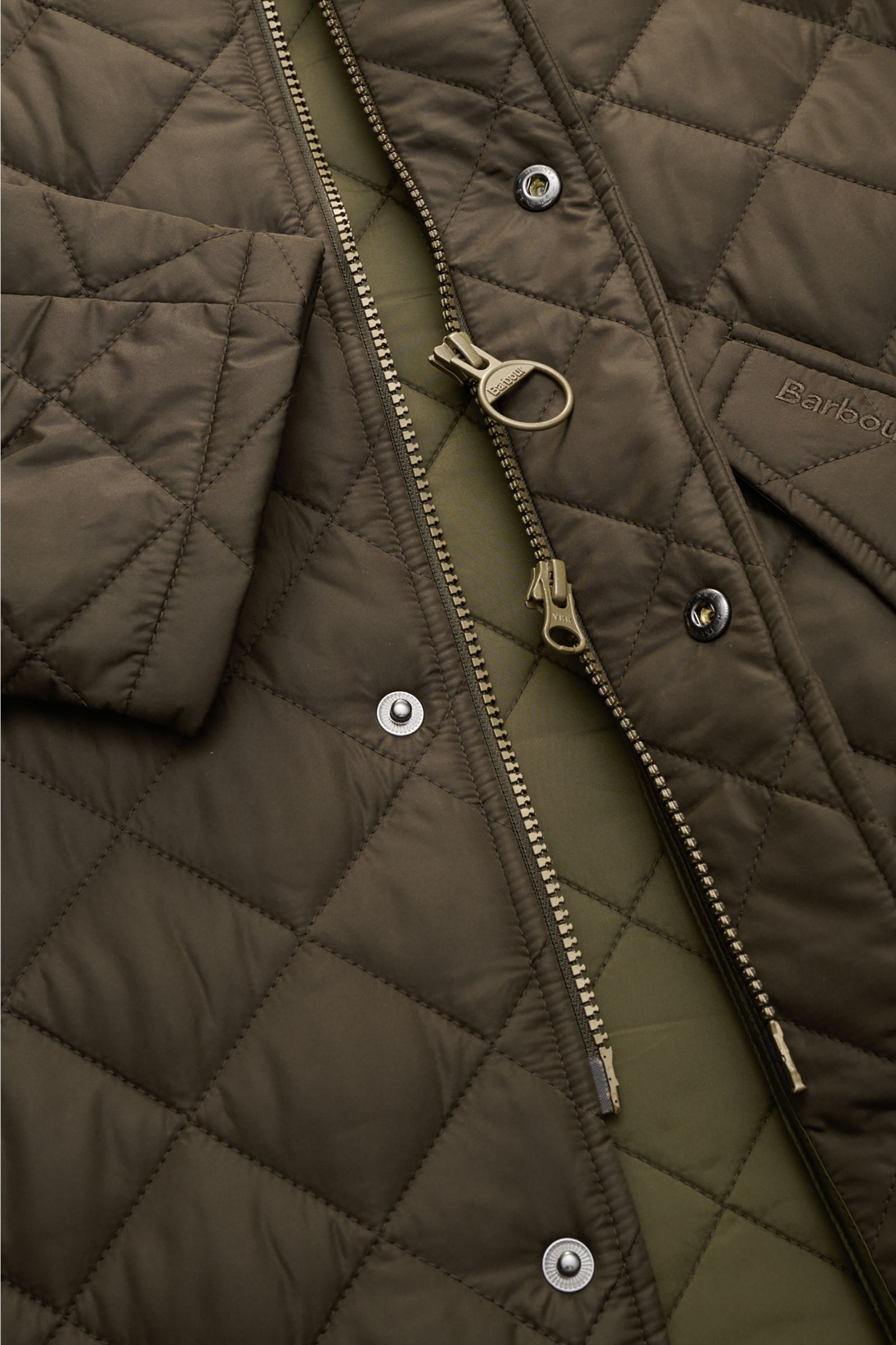 Close-up of Barbour Quilted jacket 'Chelsea Sportsquilt' olive from a top-front angle showing quilted microfiber fabric, two-way zip, snap buttons, and angled front pockets.

Perfect for flexible layering: The unlined quilted jacket 'Chelsea Sportsquil