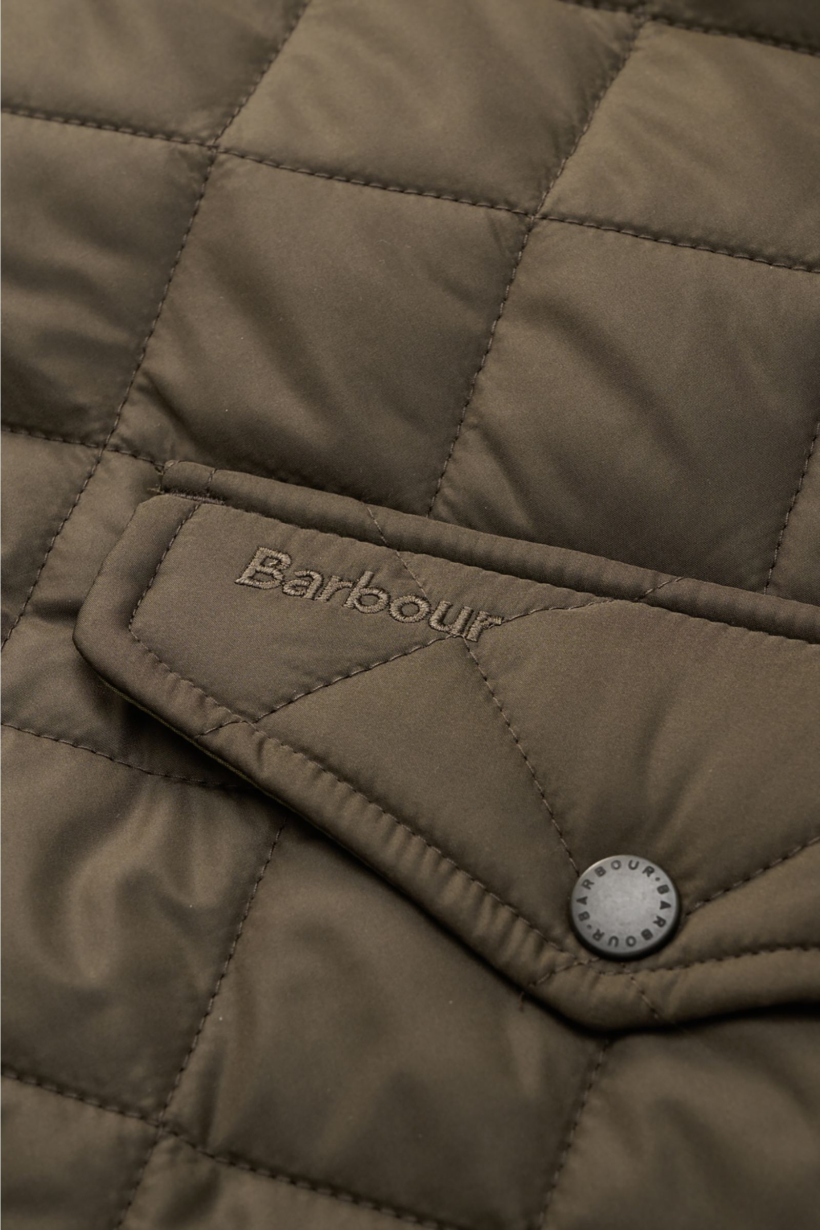 Close-up front view of Barbour Quilted jacket 'Chelsea Sportsquilt' olive showing quilted microfibre fabric, flap pocket with snap button, and tonal Barbour stitching. Perfect for flexible layering: The unlined quilted jacket 'Chelsea Sportsquilt' by BARB