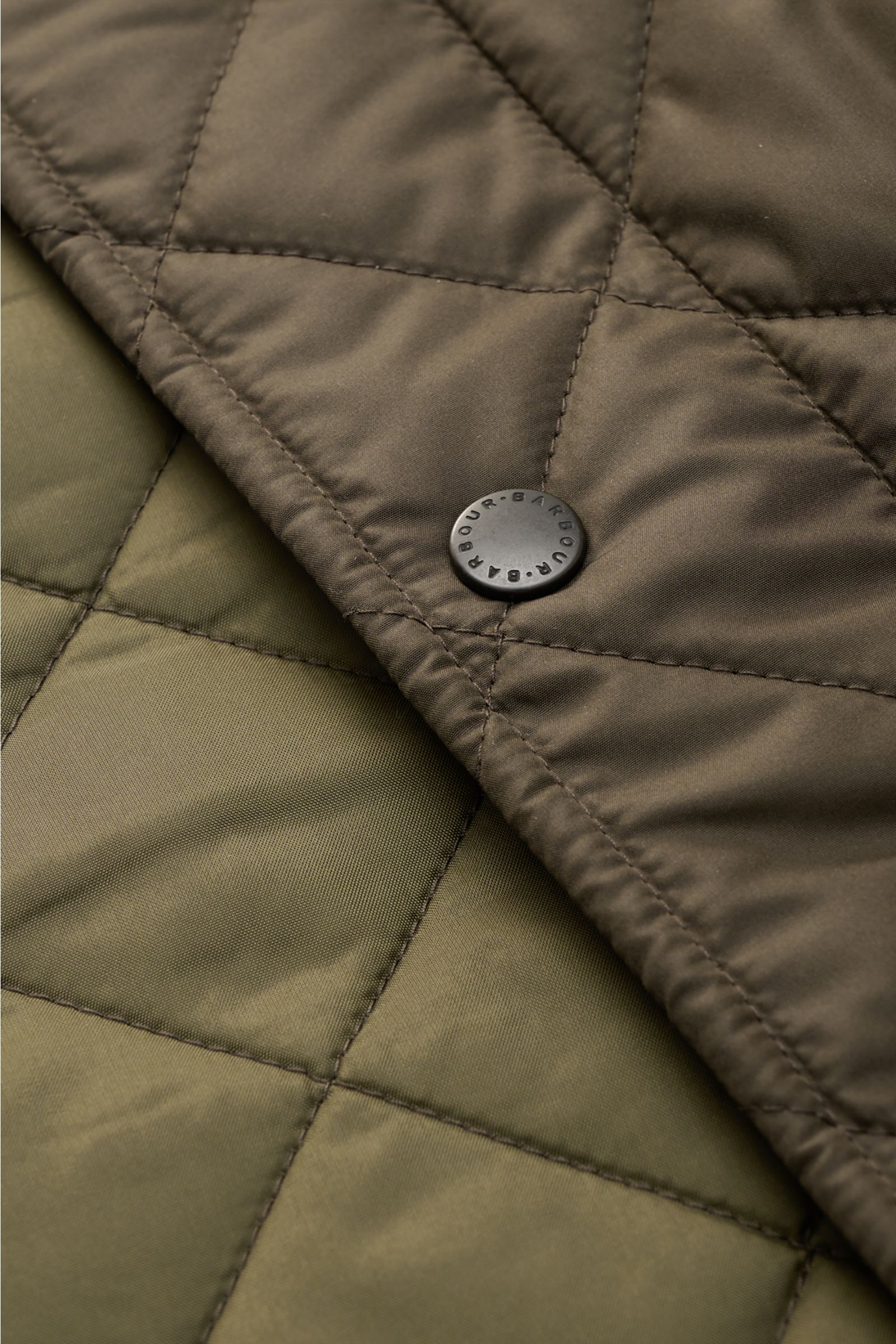 Close-up front perspective of the Barbour Quilted jacket 'Chelsea Sportsquilt' olive showing quilted microfibre, tonal stitching, and Barbour snap button. Perfect for flexible layering: The unlined quilted jacket 'Chelsea Sportsquilt' by BARBOUR has light