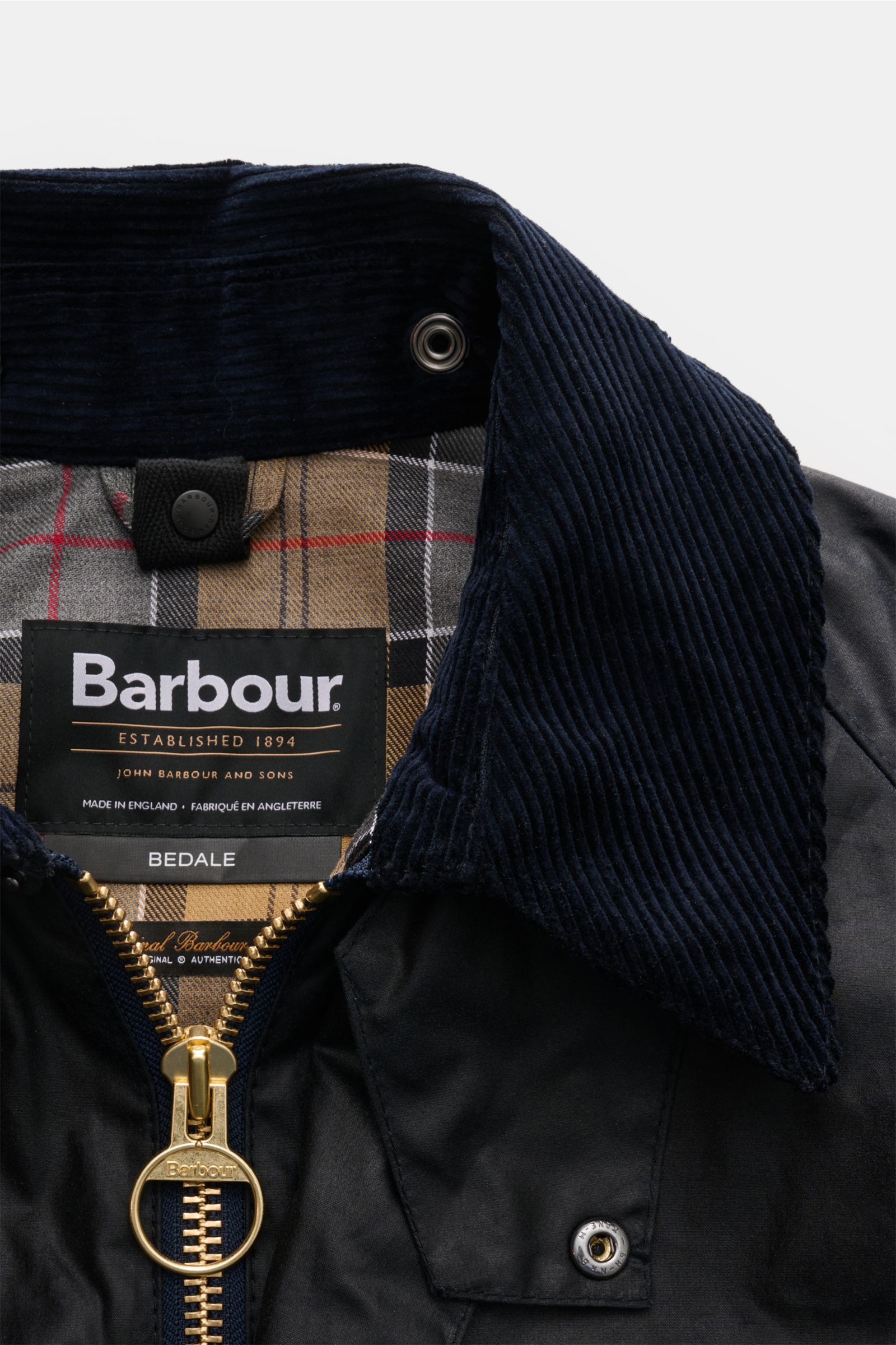 Close-up front view of Barbour Waxed jacket 'Bedale' dark navy showing corduroy collar, gold zipper, snap button, and signature tartan lining. Perfectly equipped for the changing seasons: The 'Bedale' from BARBOUR is made from waxed cotton and features th