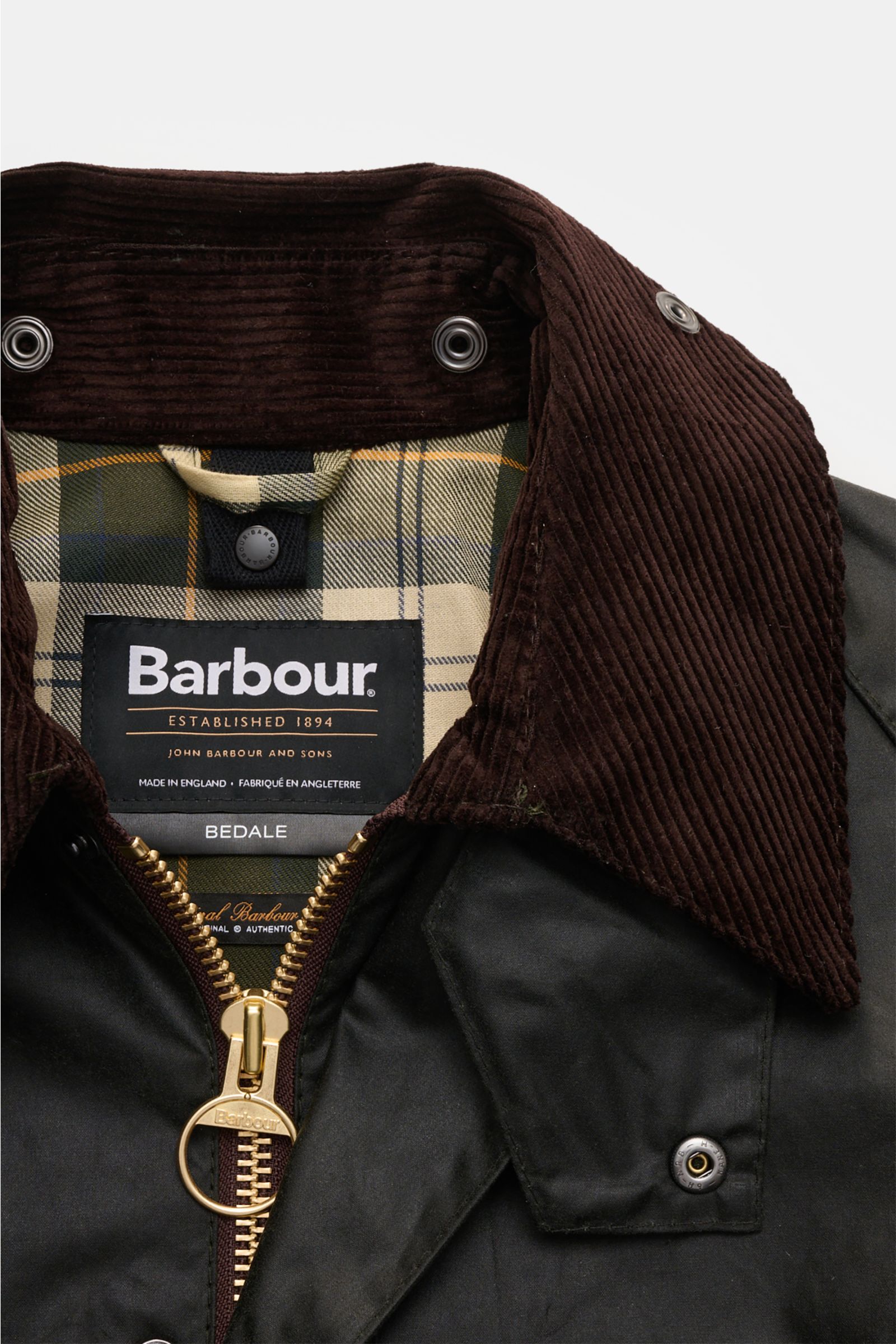Close-up front view of Barbour Waxed jacket 'Bedale' dark green showing waxed cotton fabric, corduroy collar, gold zipper, and signature tartan lining.

Description: Perfectly equipped for the changing seasons: The 'Bedale' from BARBOUR is made from waxed