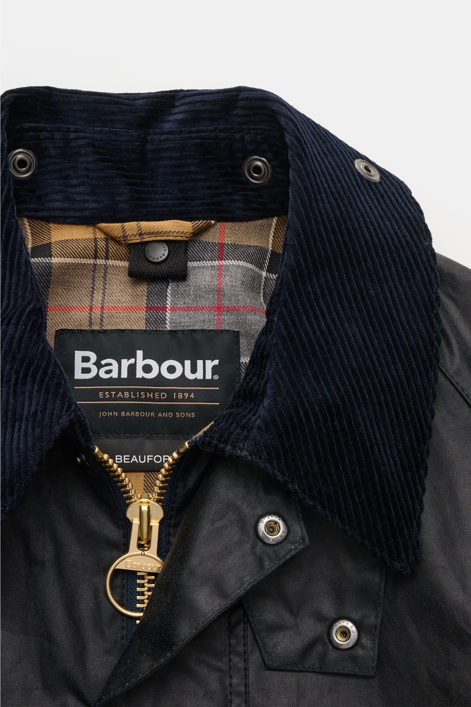 Barbour Wachsjacke 'Beaufort' dark navy aus gewachster Baumwolle, Cordkragen, Tartan-Futter, Reißverschluss und Druckknöpfen, Nahaufnahme von oben.