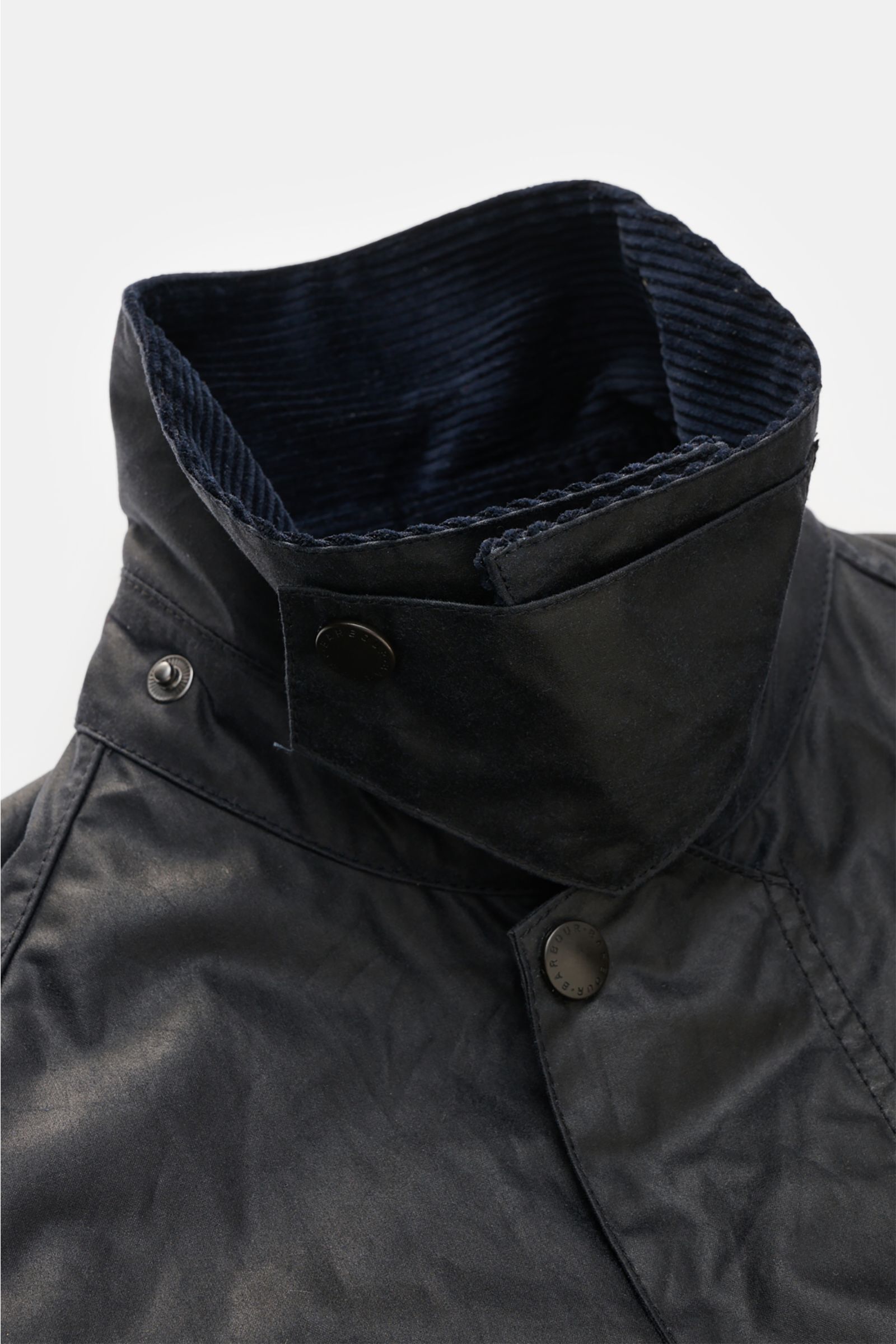Close-up front view of the Barbour Waxed jacket 'Beaufort' dark navy showing the stand-up collar with corduroy trim and snap buttons.

Description: A true classic in the British outdoor tradition: The waxed jacket 'Beaufort' by BARBOUR is made of robust, 