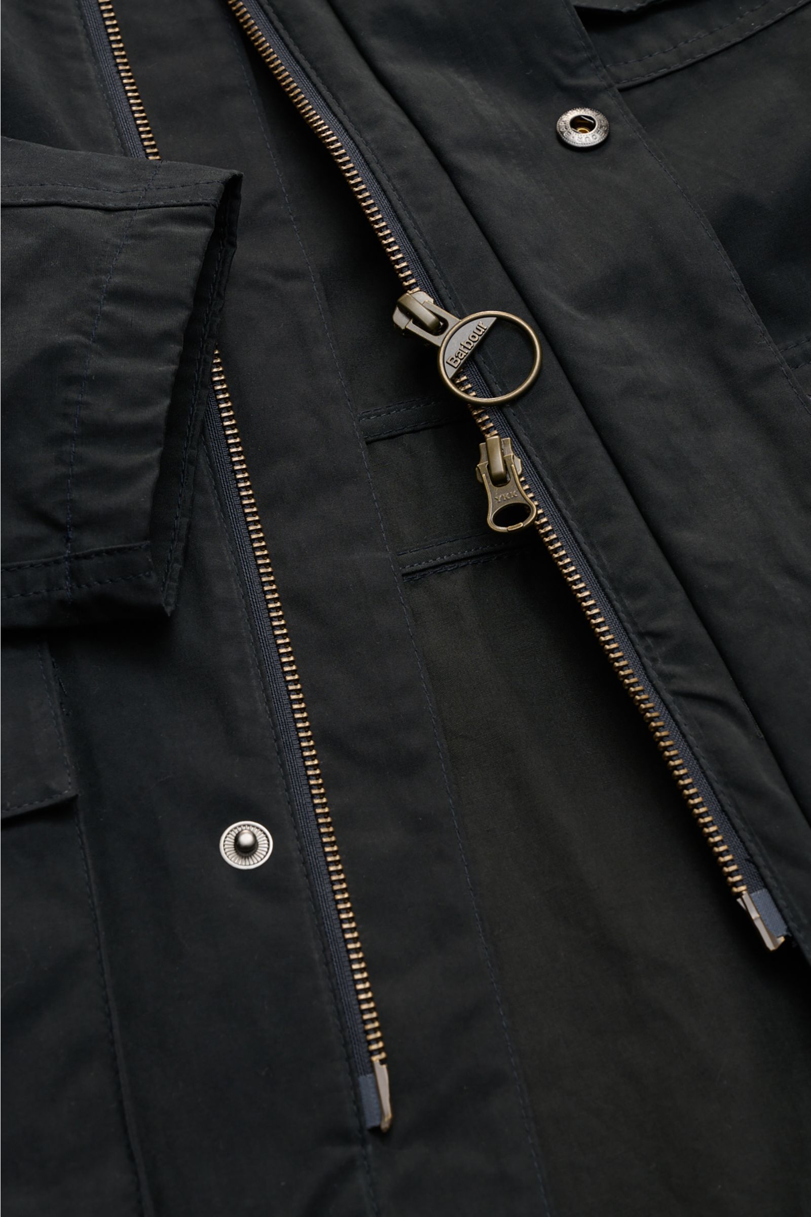 Close-up front view of the Barbour Field jacket 'Sanderling' navy showing the robust two-way zip, snap buttons, and velvety cotton-microfiber fabric, highlighting its functional, lightweight design. Lightweight, functional and in classic style: The versat