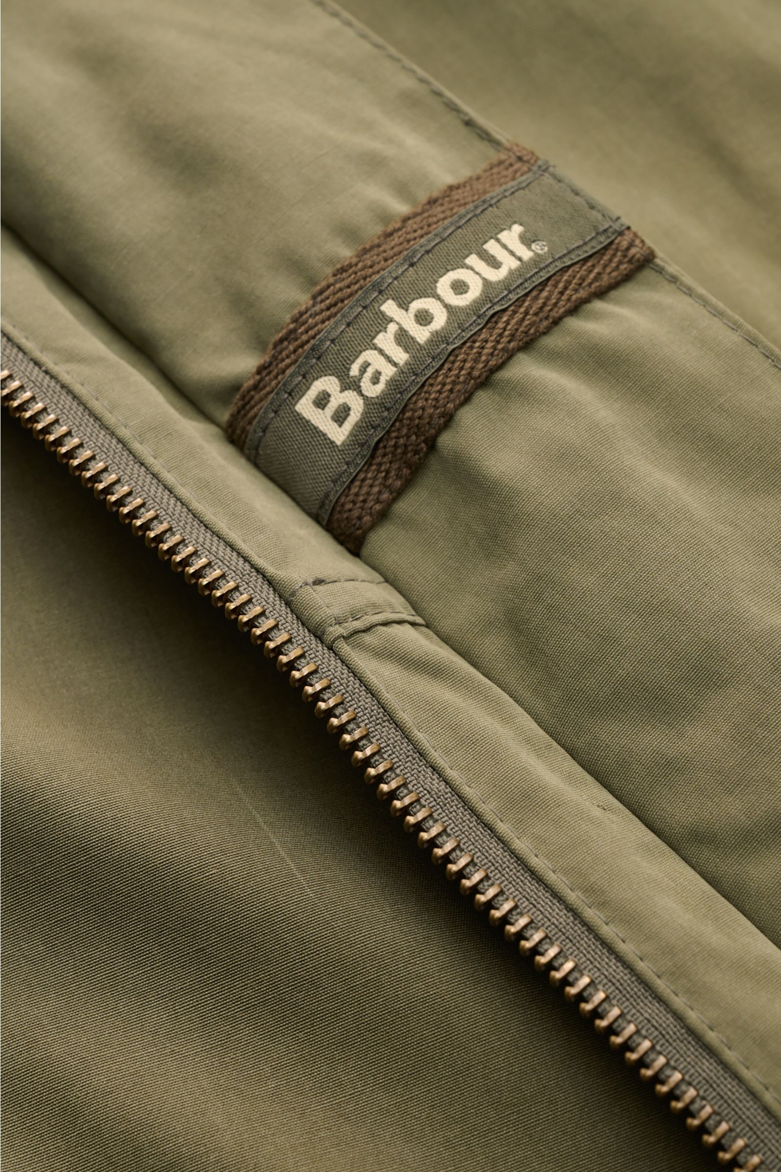 Close-up front view of Barbour Field jacket 'Sanderling' olive showing zipper and Barbour logo on lightweight cotton-microfibre fabric.

Lightweight, functional and in classic style: The versatile field jacket 'Sanderling' by BARBOUR is made of comfort