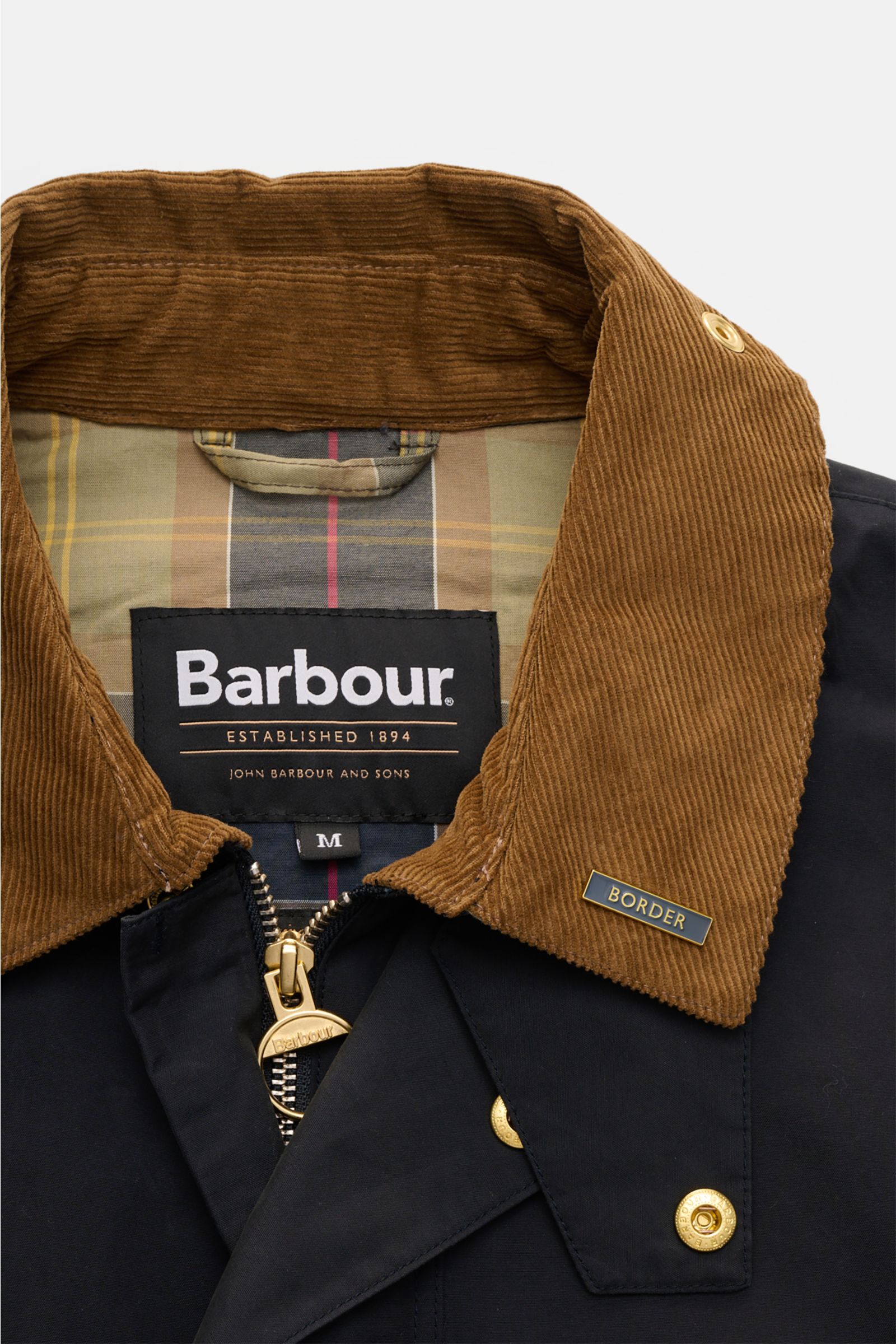 Alt tag (125 characters max): Close-up front view of Barbour Parka 'Icons Border' dark navy with brown corduroy collar and tartan lining.

Description: 
Create classically elegant casual looks in quintessentially English style with the lightweight park