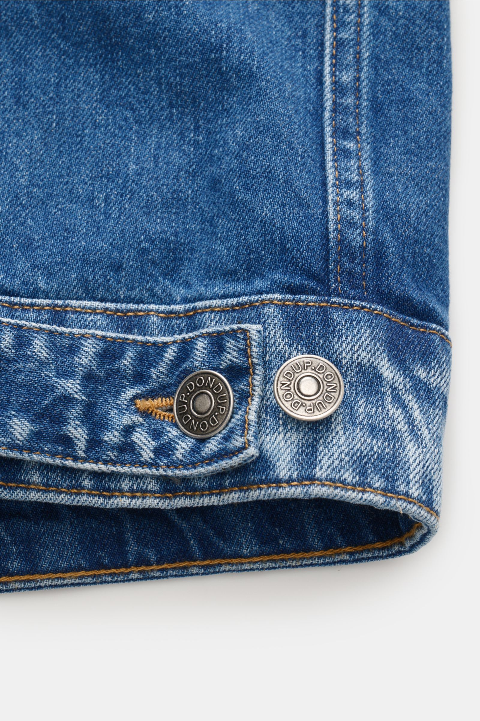 Close-up view of the hem of the Dondup Denim jacket blue showing detailed stitching and two metal buttons engraved with 'DONDUP.' Timeless denim essential: The DONDUP denim jacket is perfect for stylish casual looks this spring.  
- Denim made of pure cot