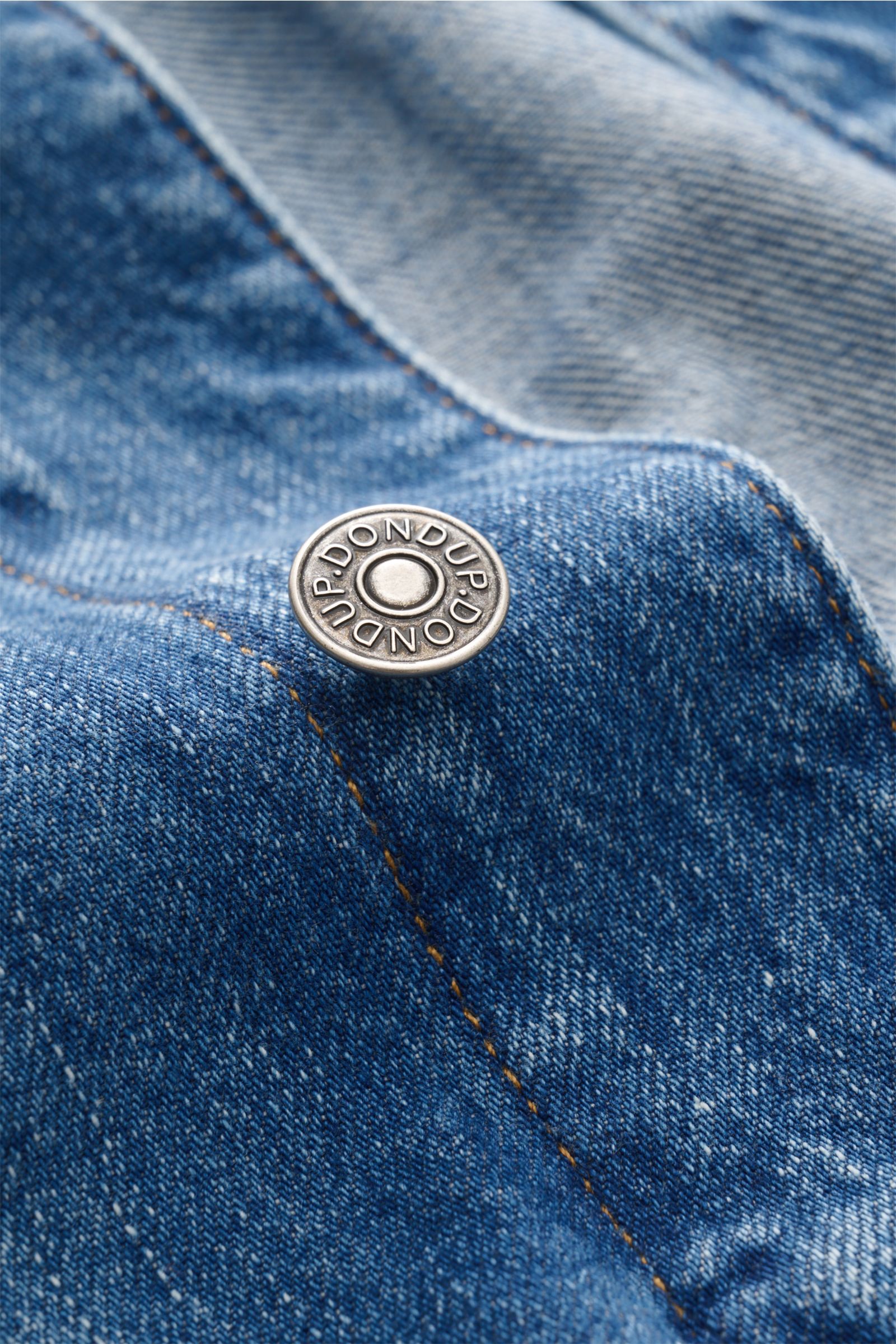Close-up front perspective of Dondup Denim jacket blue showing silver branded button and contrasting seam on pure cotton fabric.

Timeless denim essential: The DONDUP denim jacket is perfect for stylish casual looks this spring.

Denim made