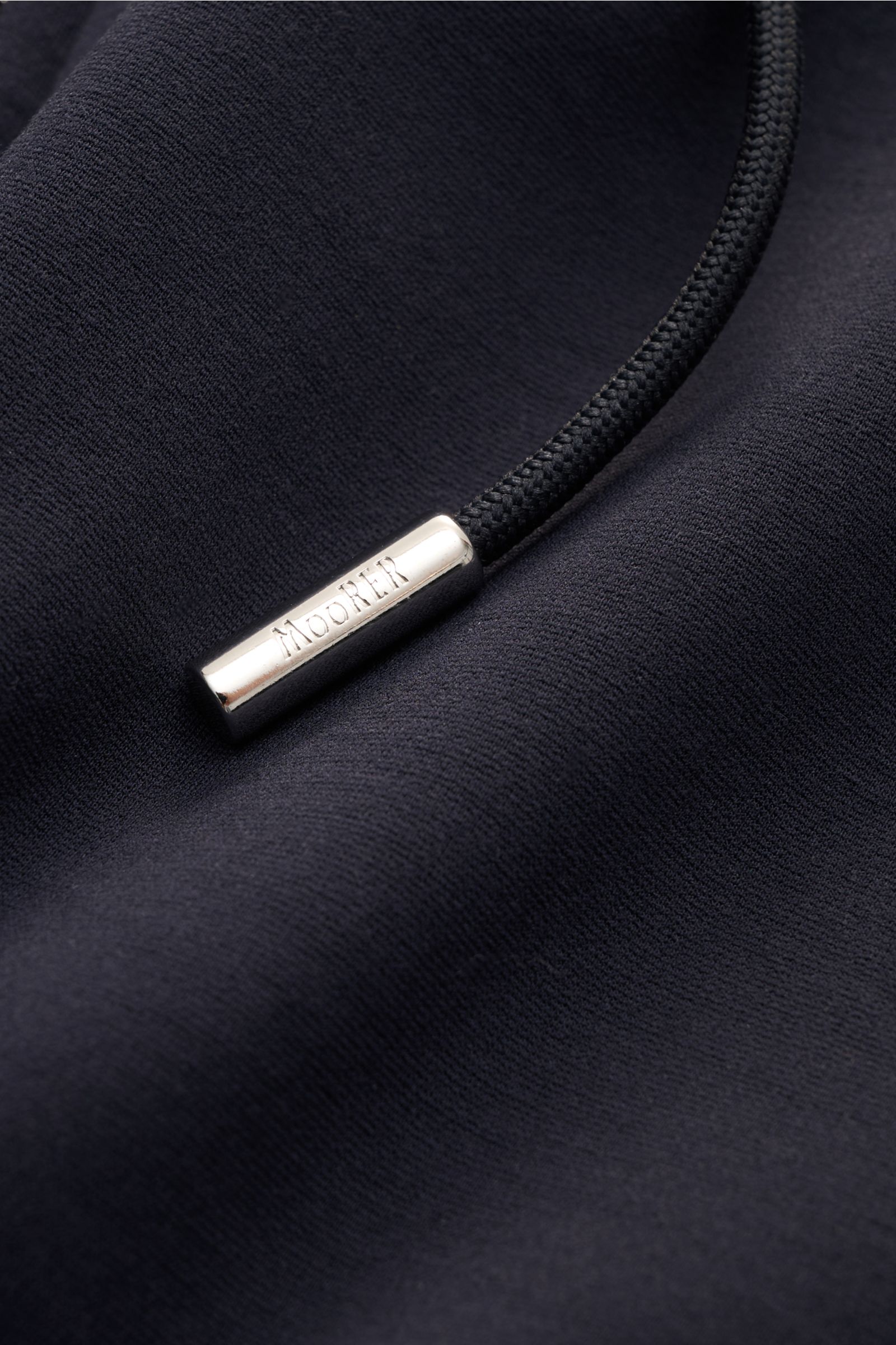 Close-up from above of the drawstring with engraved Moorer logo on the navy Moorer Sweat jacket 'Matthew Felpa' navy, showing soft double-sided knit fabric.

Sporty luxury: This sweat jacket by MOORER in a double-sided knit is exceptionally soft with exce