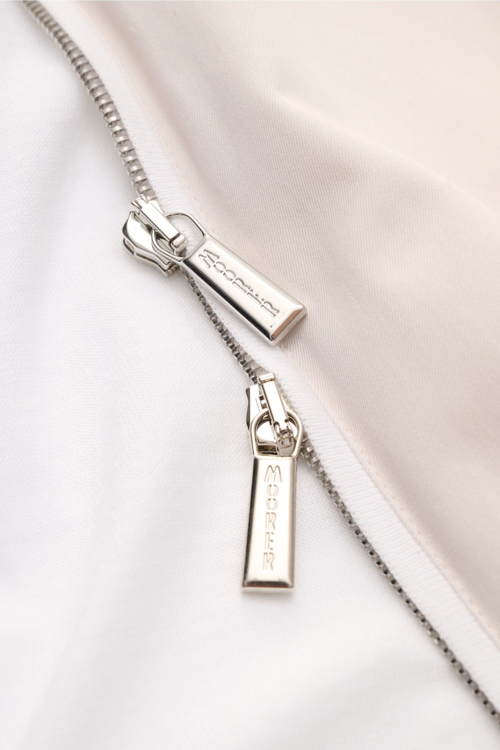 Close-up view of the silver two-way zip on the Moorer Jersey blouson 'Tolly' white/beige, showing fine twill cotton fabric. Sporty and elegant for warm days: With a twill trim and the finest 'Sea Island' cotton, the jersey blouson by MOORER is made of exc
