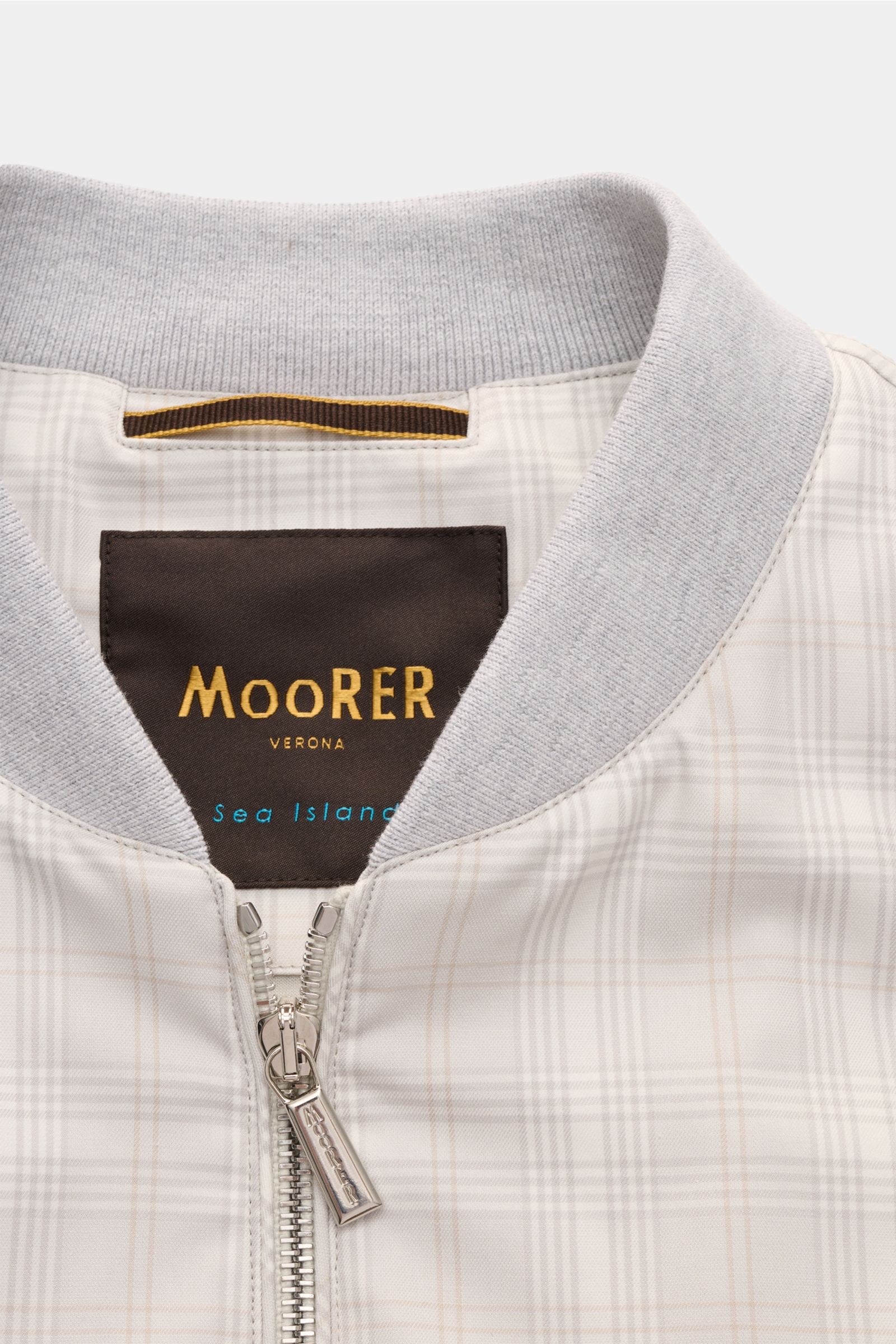 Close-up front view of Moorer Blouson 'Sorano' light grey/beige/cream checked with ribbed collar, two-way zip, and classic checked pattern, made of pure Sea Island cotton.

The luxurious reinterpretation of a blouson: Made of the finest 'Sea Island' cotto