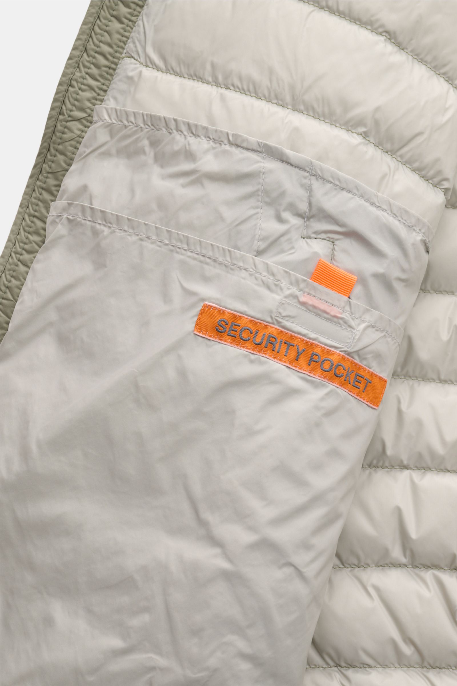 Close-up view of the inside of the Parajumpers Down blouson 'Breving' sage, showing the security pocket with orange label and microfibre lining. Style meets function: This down blouson by PARAJUMPERS keeps you comfortably warm on cold days and is versatil