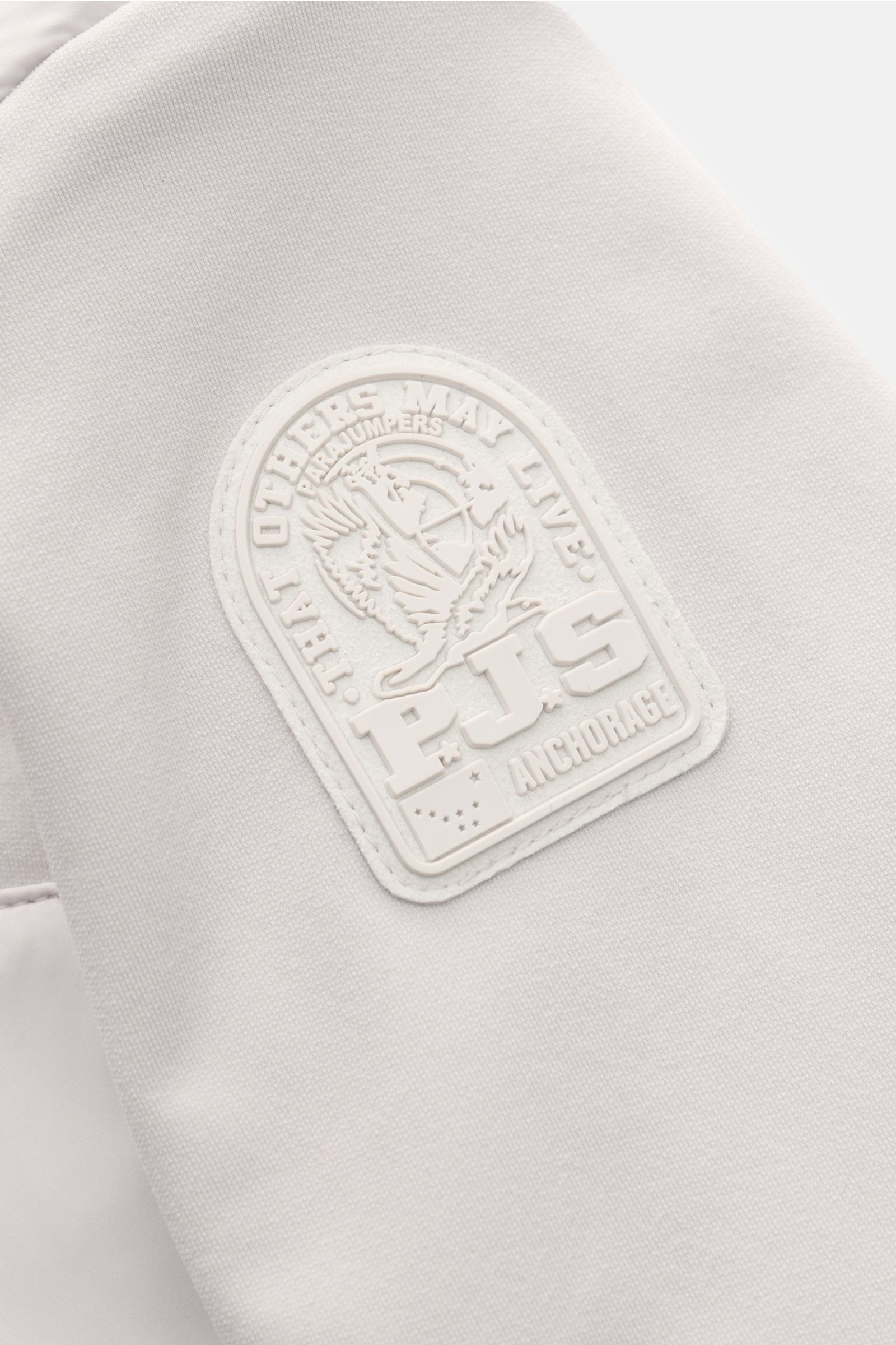 Close-up front-side view of Parajumpers Jacket 'Douglas' sand featuring a white embossed logo patch on soft, high-quality microfibre fabric.

A functional piece for the transitional season: The jacket 'Douglas' by PARAJUMPERS has a functional, pared do