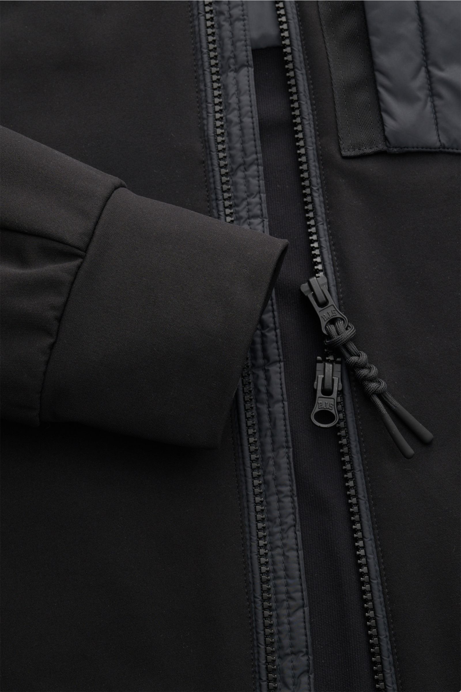 Close-up from above of the Parajumpers Jacket 'Douglas' black showing the cuff, two-way zip with paracord pull, and soft microfiber fabric. A functional piece for the transitional season: The jacket 'Douglas' by PARAJUMPERS has a functional, pared down de